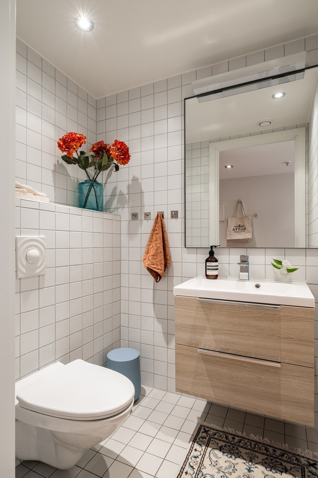 Badet har varmekabler i gulvet og er innredet med heldekkende servant på underskap, speil med belysning, vegghengt toalett og dusj med herdet glassdører. Galleribilde