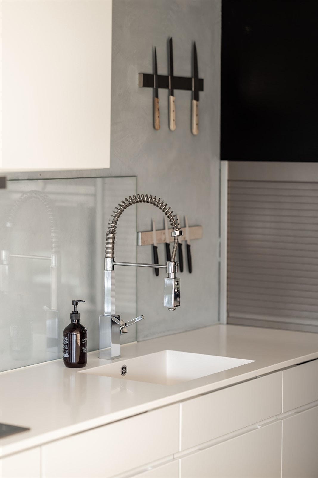 Kjøkken med tøff kontrastvegg i grå kalkmaling. Tapwell kjøkkenarmatur med hånddusj. Downlights gir godt arbeidslys i rommet. Benkeplaten er i slitesterk kompositt med helstøpt kum og ett-greps blandebatteri. Varmekabler i gulv. Galleribilde