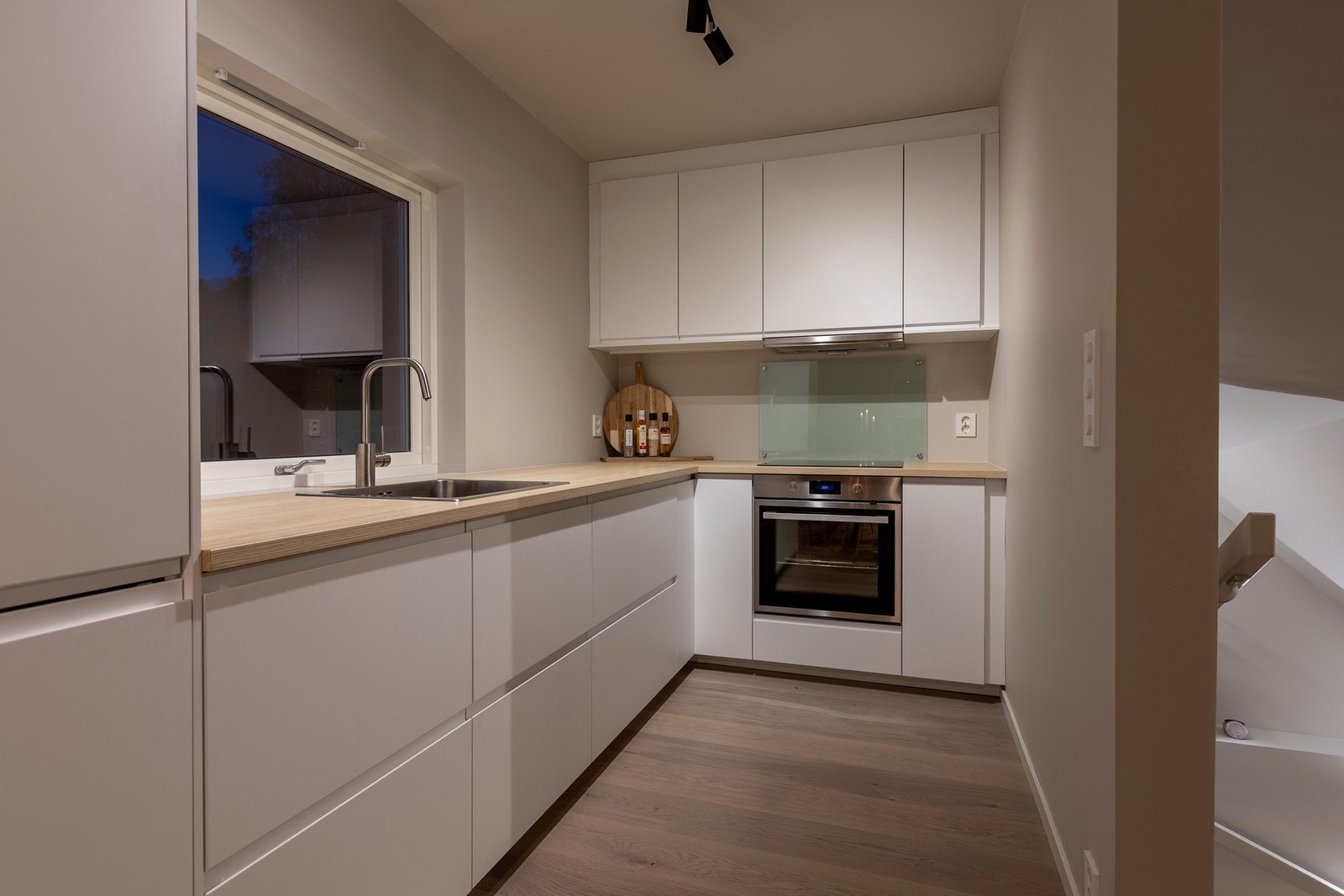 Lyst, lekkert og stilrent kjøkken med glatte overflater. Galleribilde