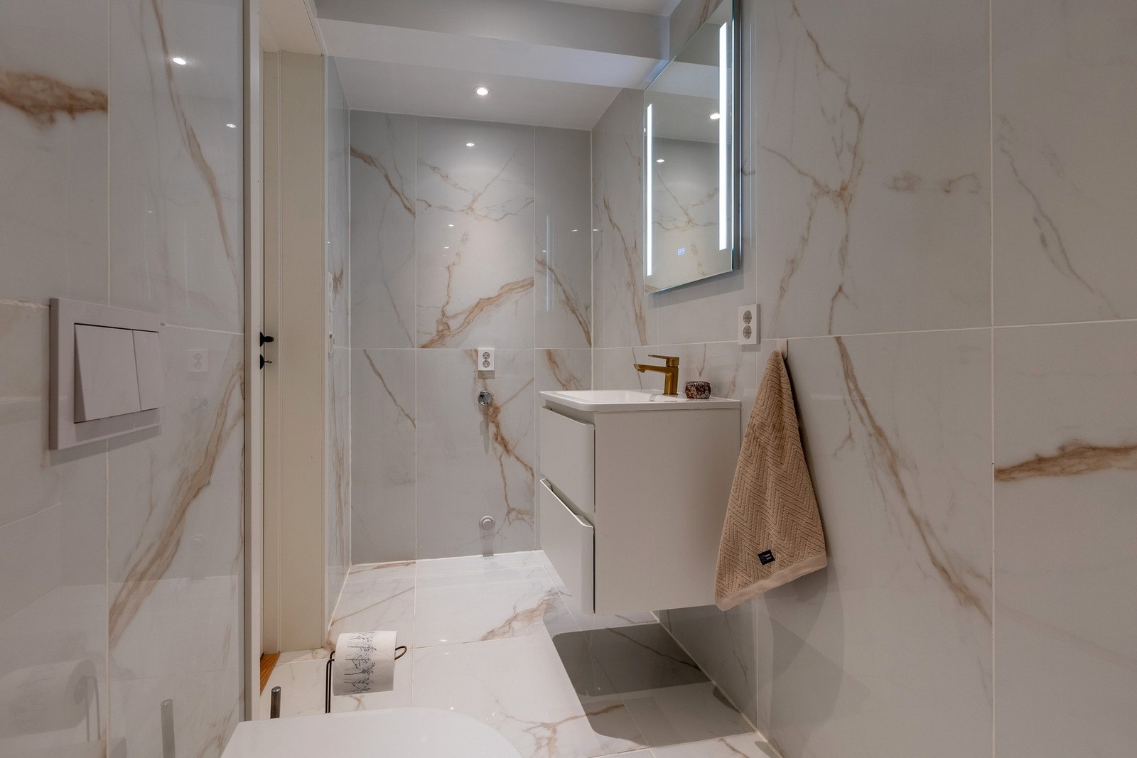 Innredet med hvit baderomsinnredning med nedfelt servant, speil og belysning. Galleribilde