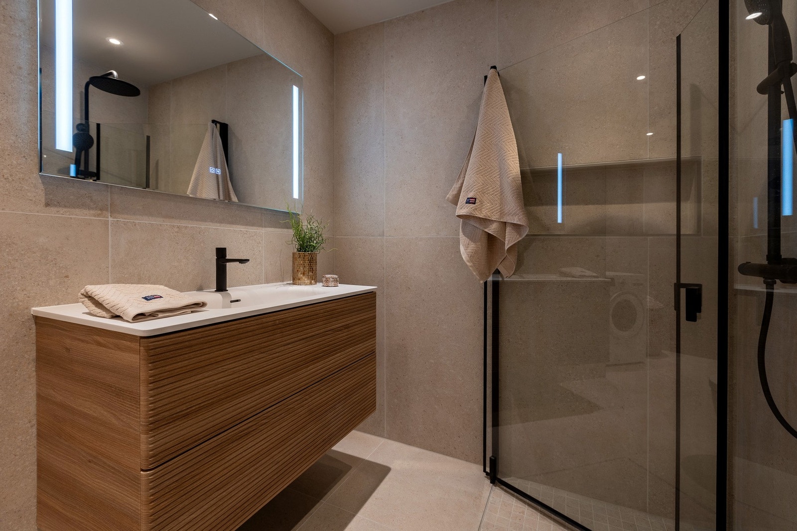 Stilig eik baderomsinnredning med skuffer, speil og belysning. Dusjhjørne med innfellbare glassvegger. Galleribilde