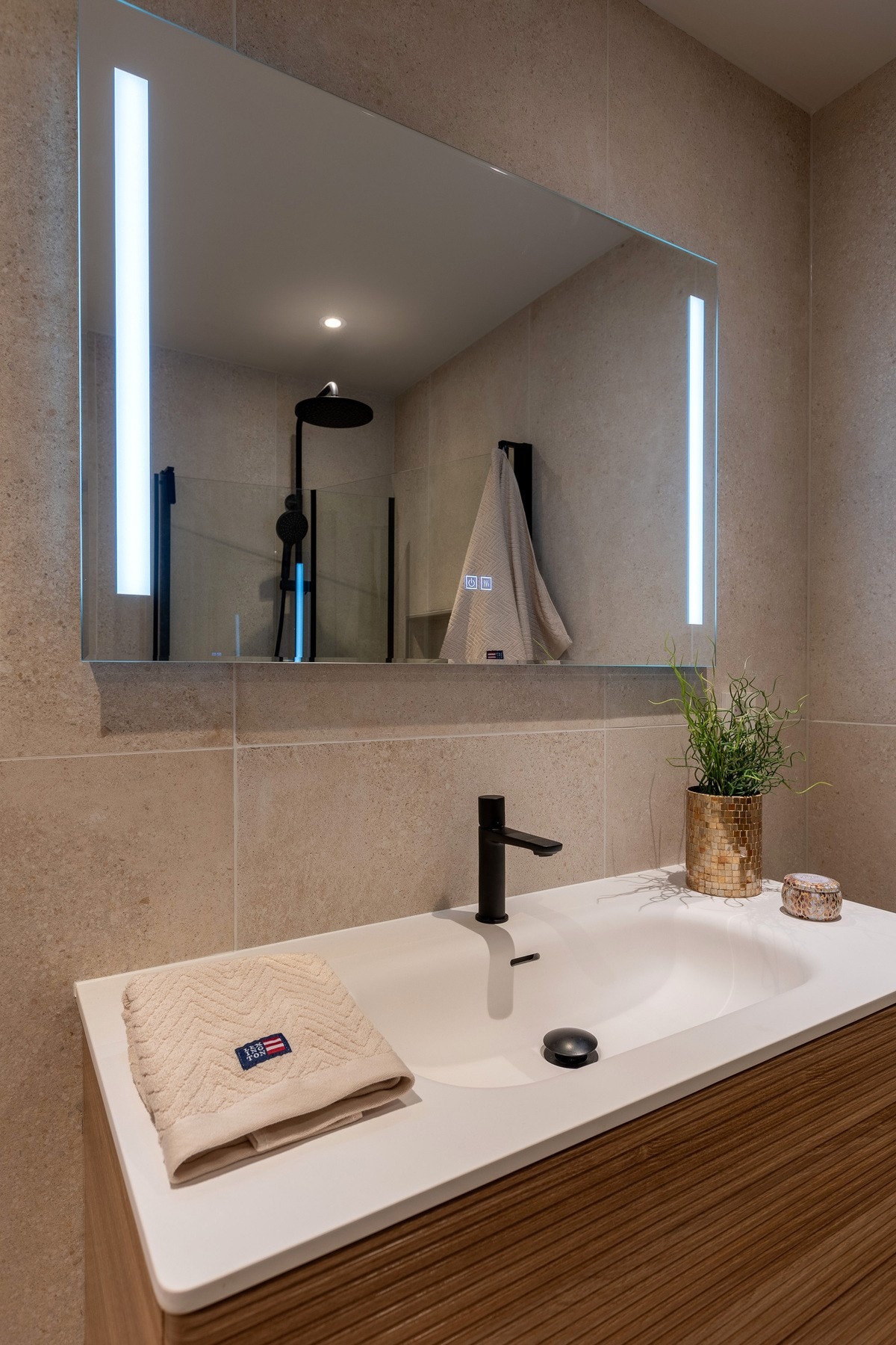 Heldekkende, nedfelt servantplate med mørkt blandebatteri. Galleribilde