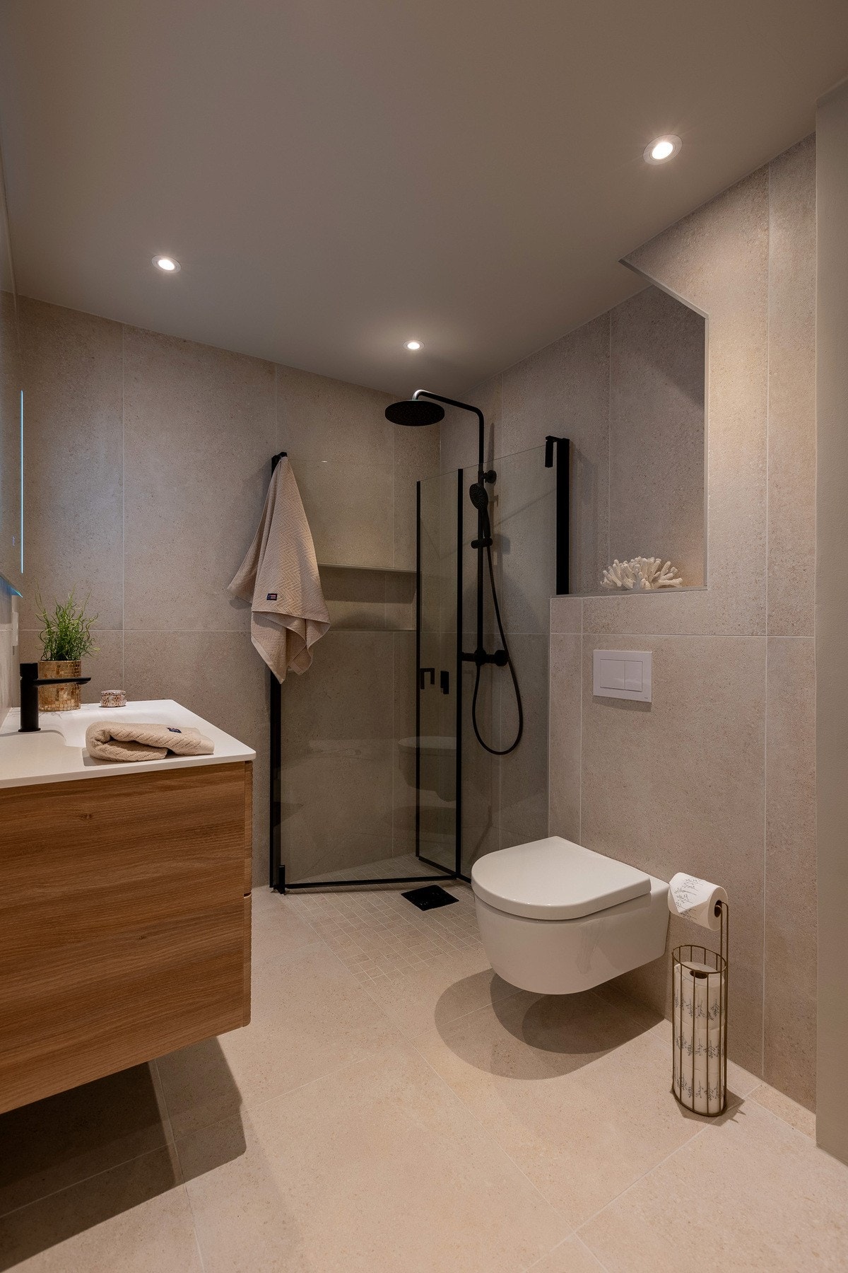 Vegghengt wc med innebygget sisterne. Flislagte overflater og gulvvarme med elektriske varmekabler. Galleribilde