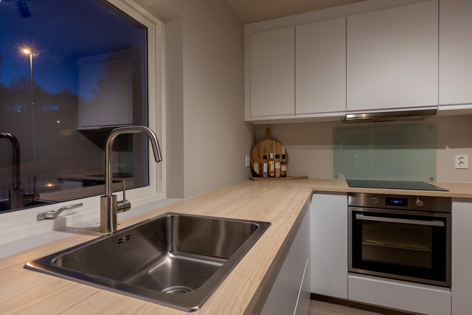 Nedfelt oppvaskkum med laminert benkeplate. Hyggelig utsyn via kjøkkenvindu mot gårdsplass. Galleribilde