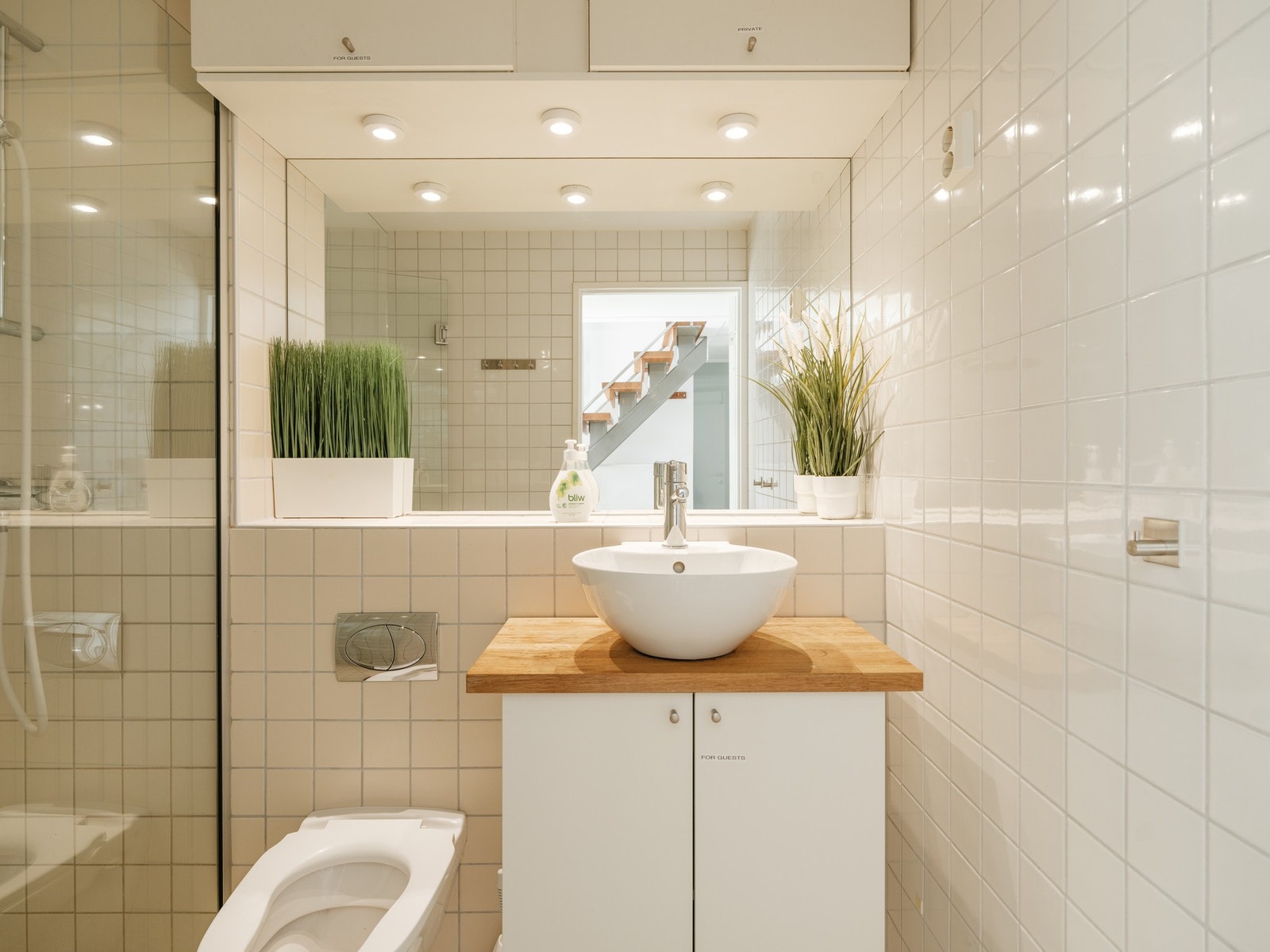 Pent og flislagt baderom med benkeskap med glatte fronter. Galleribilde