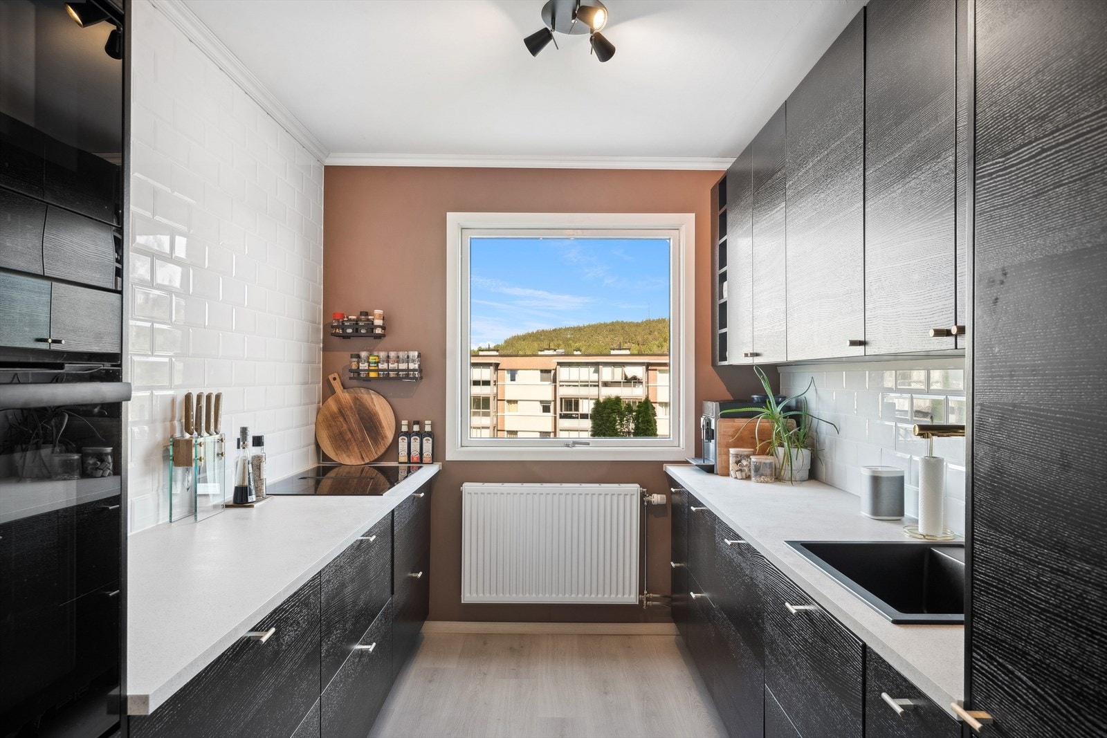 Moderne kjøkken med integrerte hvitevarer som kjøleskap, komfyrtopp, stekeovn og oppvaskmaskin. Galleribilde