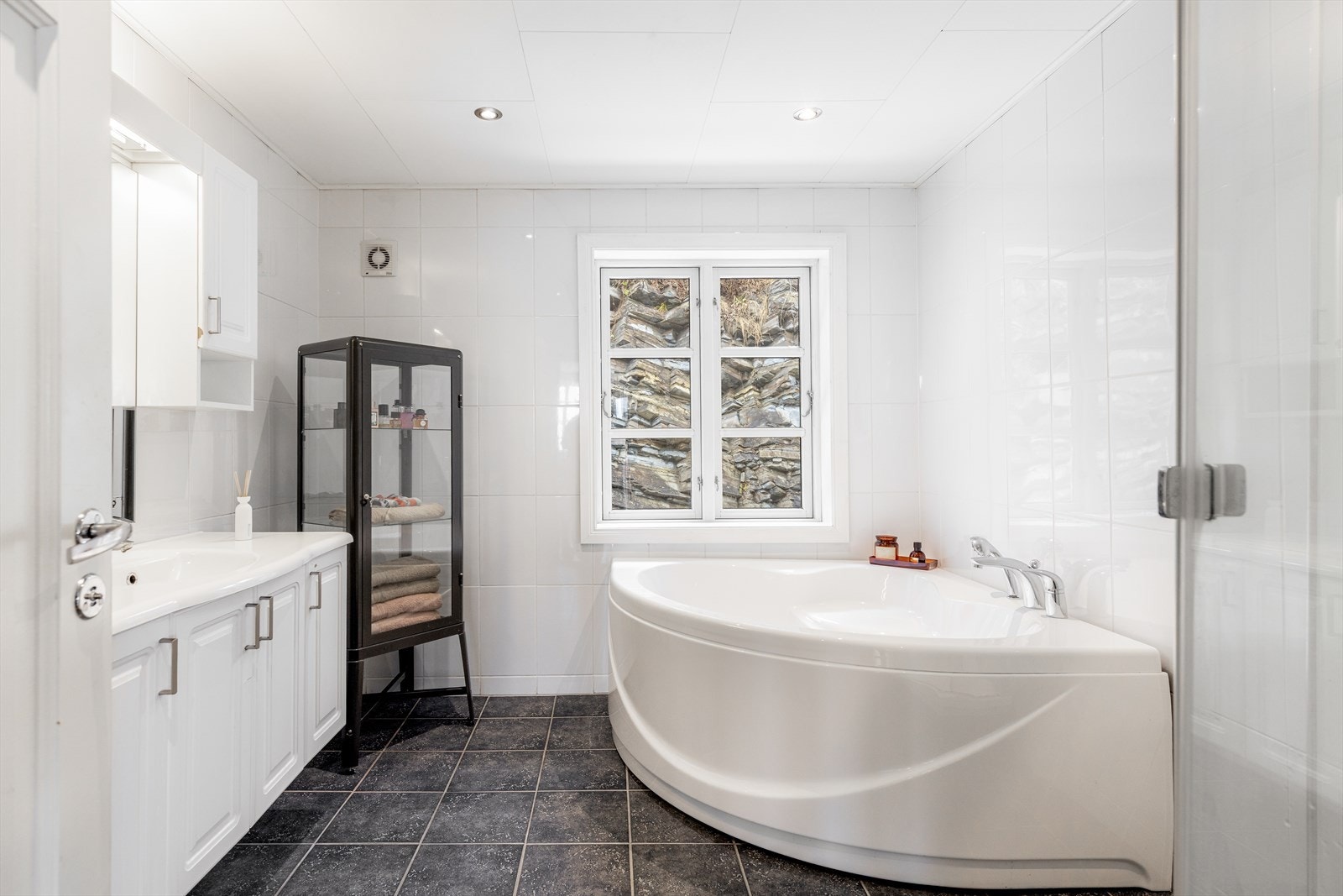 Romslig, flislagt bad med innfelte spotter i tak. Galleribilde