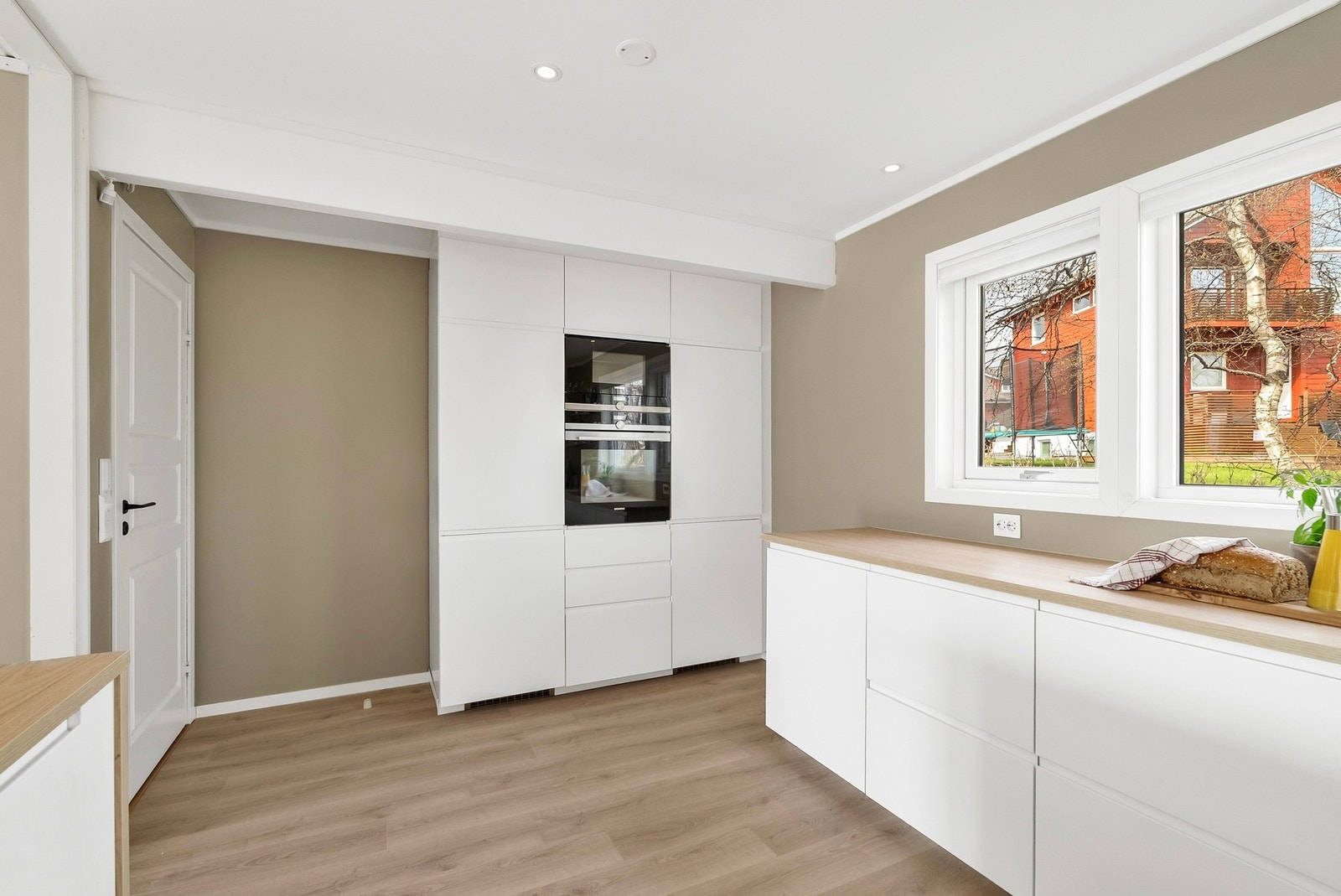 Høyskap med integrert komfyr, mikro, fryseskap og kjøleskap. Integrert oppvaskmaskin plassert under benken. Galleribilde