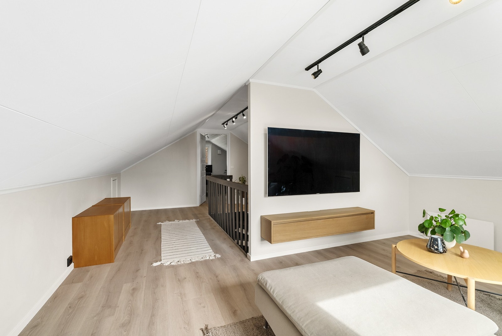 Loftstue med praktisk vegg som deler rommet og gir rommet en naturlig plassering av f eks TV Galleribilde