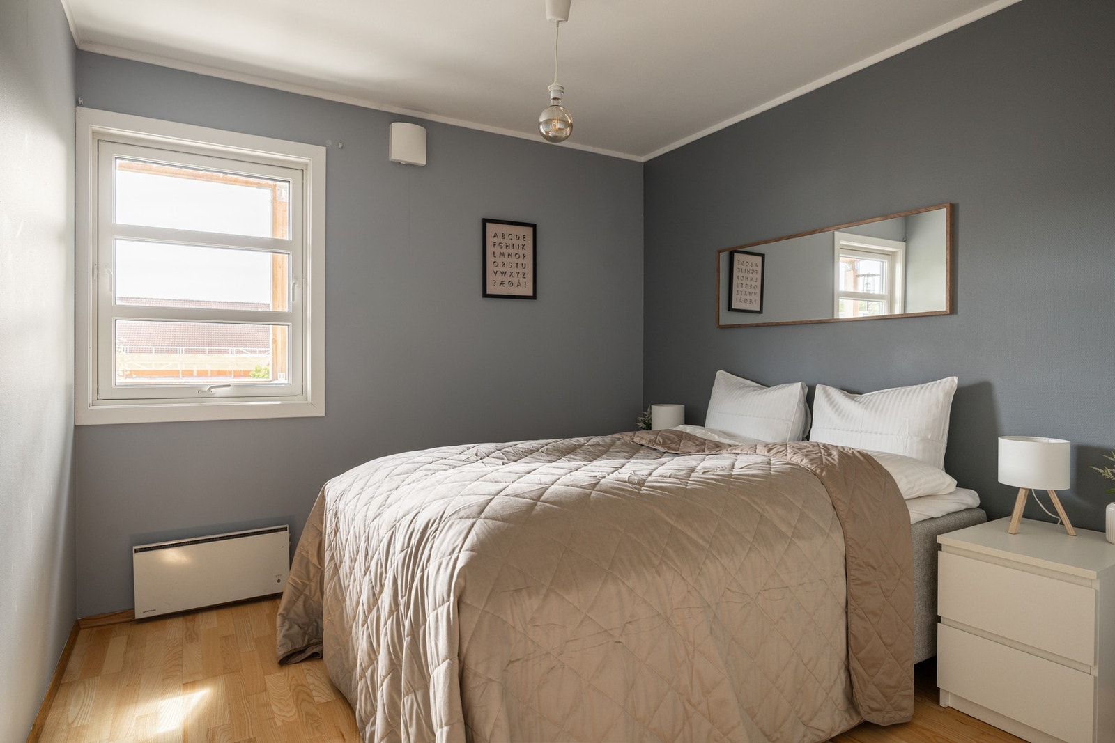 Et luftig soverom med god plass til dobbeltseng og nattbord på sidene. Galleribilde