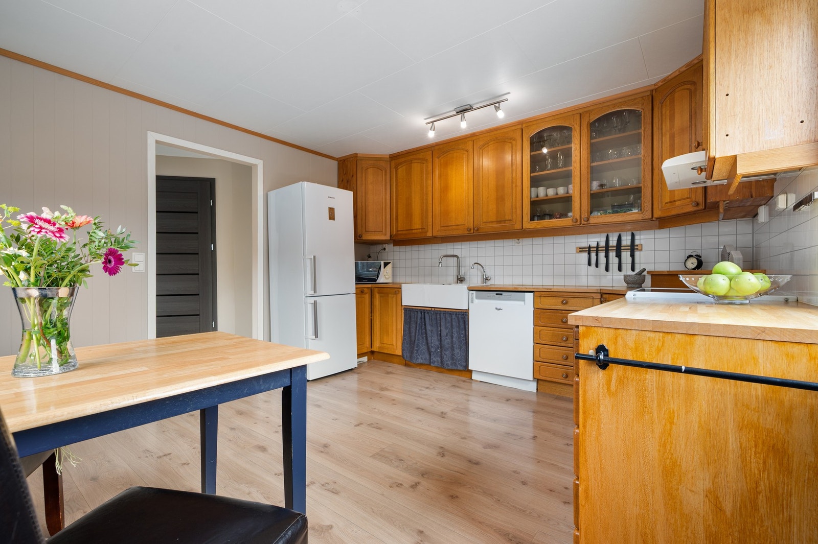 Det er dobbel keramisk oppvaskkum og kitchenboard mellom benkeplate og overskap Galleribilde