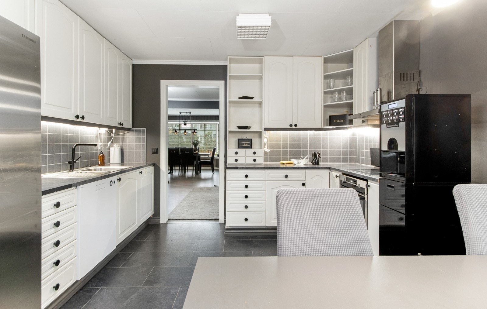 Innredningen i er i en klassisk stil som er lett å like med hvite profilerte fronter, åpne hyller, noe nyere laminatebenkeplate, samt nedfelt skylle- og oppvaskkum. Galleribilde