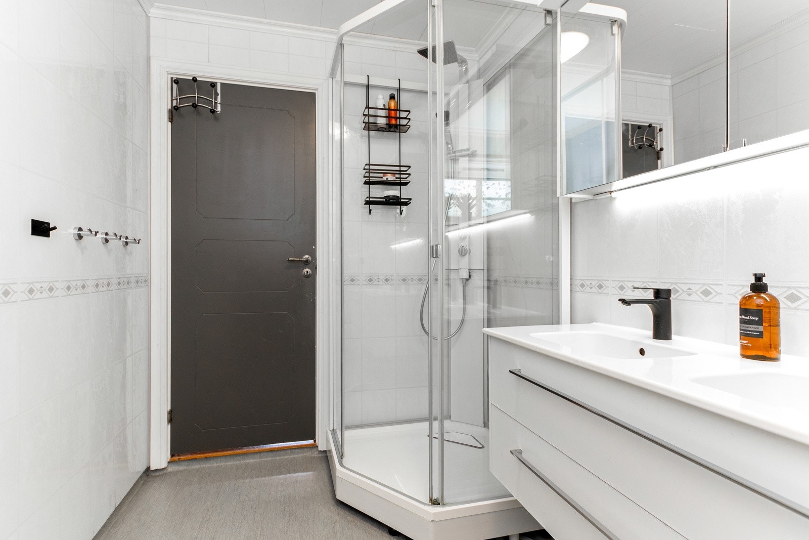 Badet har ellers veggmontert toalett og dusjkabinett med regnfallsdusj. Galleribilde