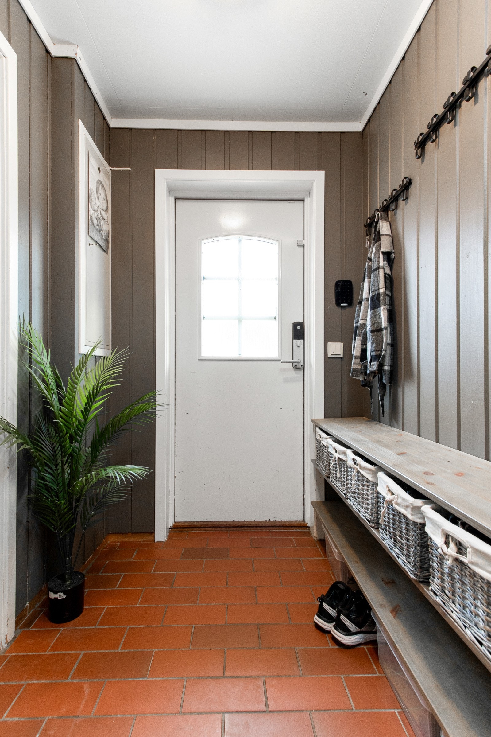 Entreen gir et trivelig førsteinntrykk av boligen med flislagt gulv og samme malte veggpanel som de fleste øvrige rom. Galleribilde