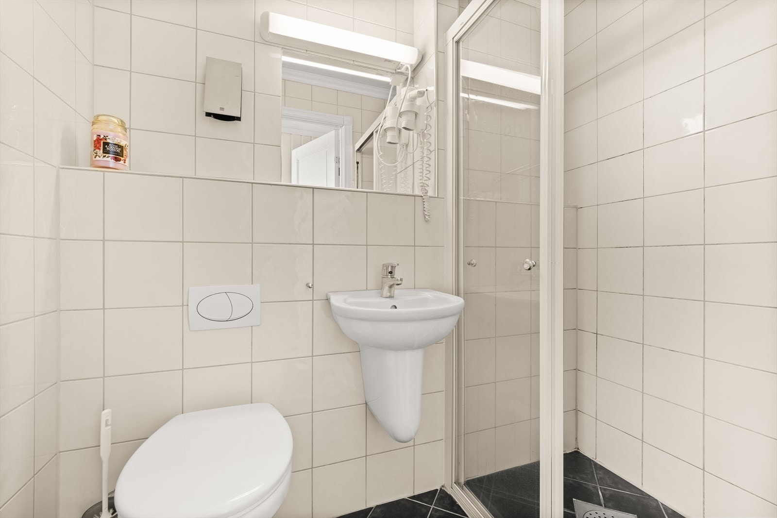 Badet i 1. etasje er innredet med vegghengt servant, innfelt speil, vegghengt toalett og dusjnisje med faste glassprofiler. Galleribilde