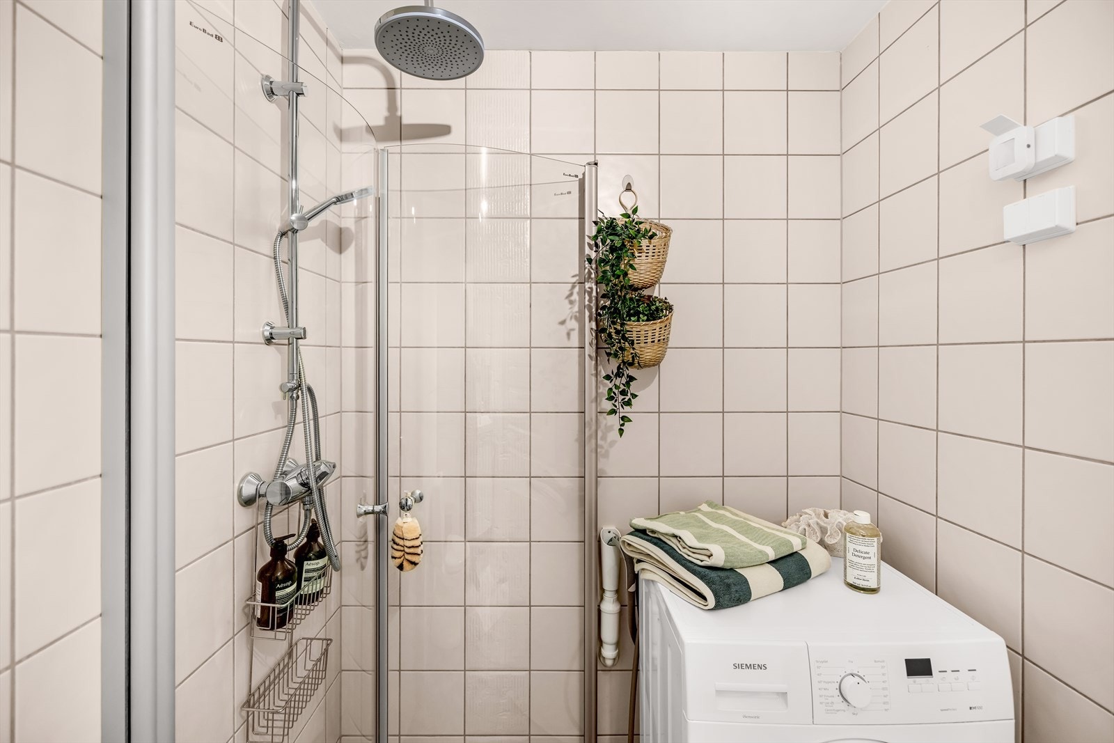 Badet består av praktisk dusjhjørne med innfellbare dusjdører, opplegg for vaskemaskin, toalett og servant med innredning Galleribilde