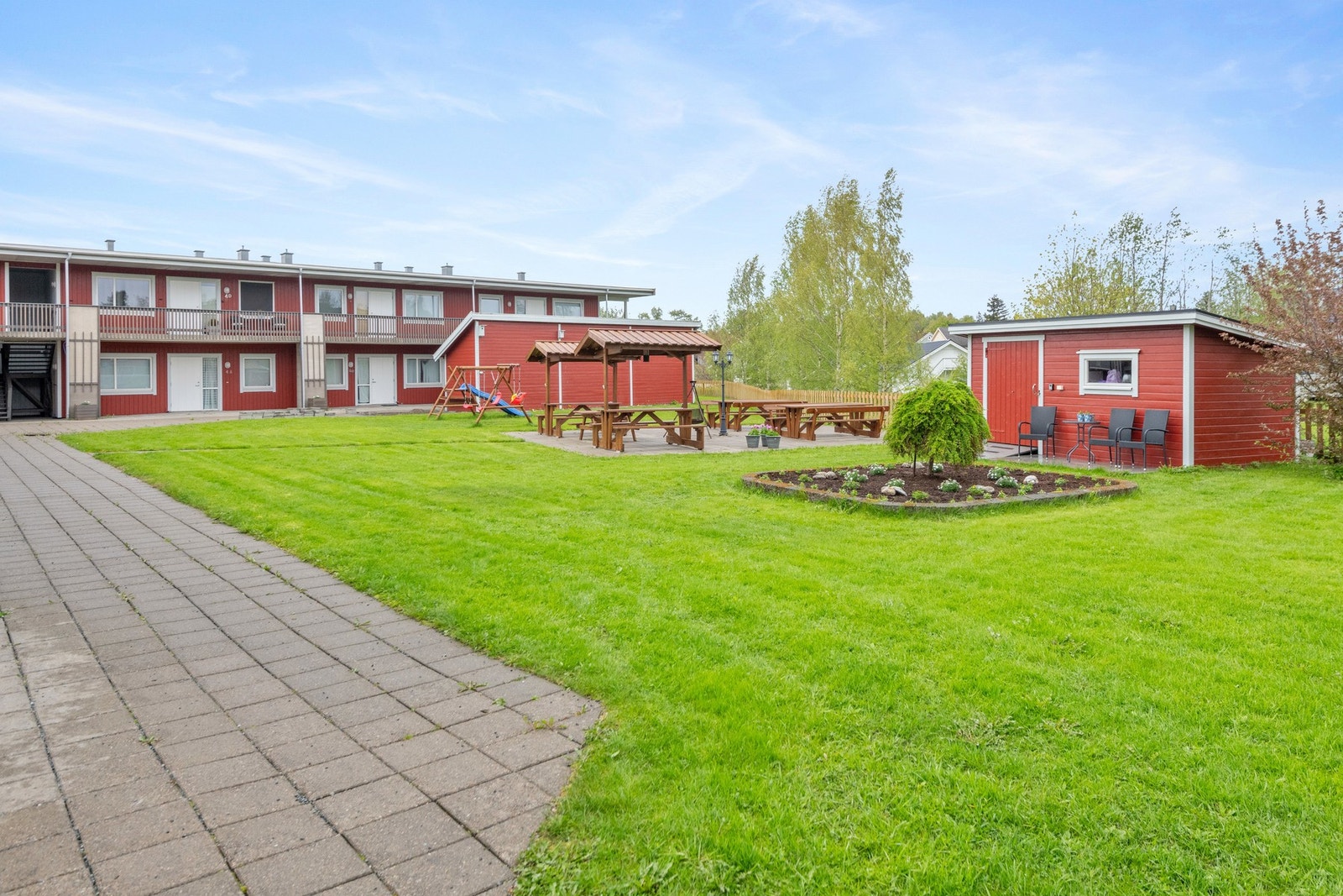 Fellesarealene har lekestativ og er beplantet med plen, prydbusker og bed. Galleribilde