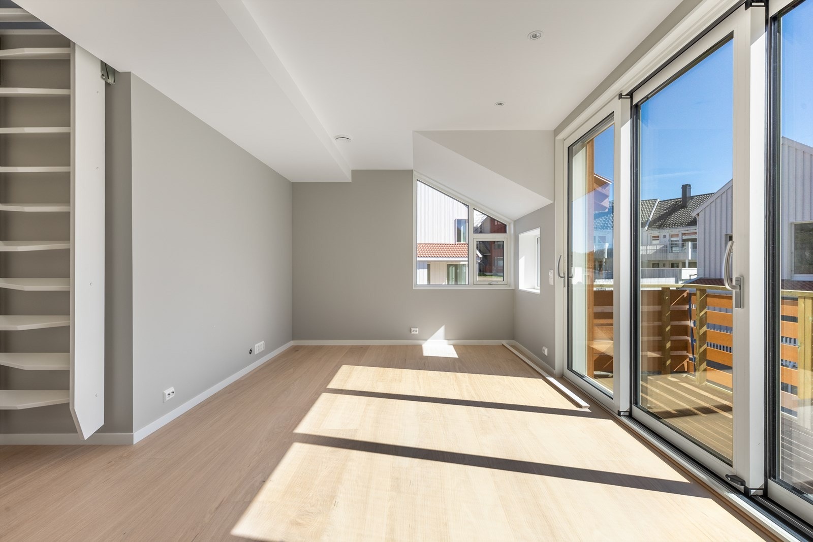 Stuen får godt med lys via vinduer og den store skyvedøren Galleribilde