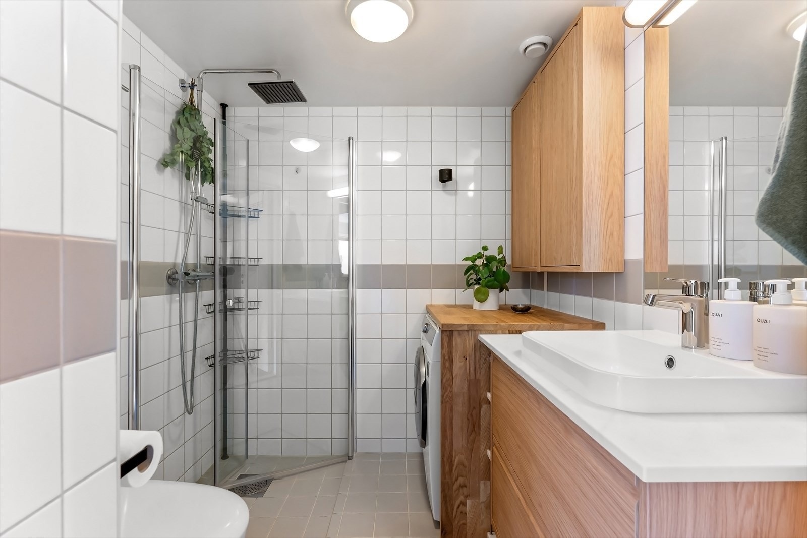 Stort og flislagt bad med varmekabler og opplegg for vaskemaskin Galleribilde