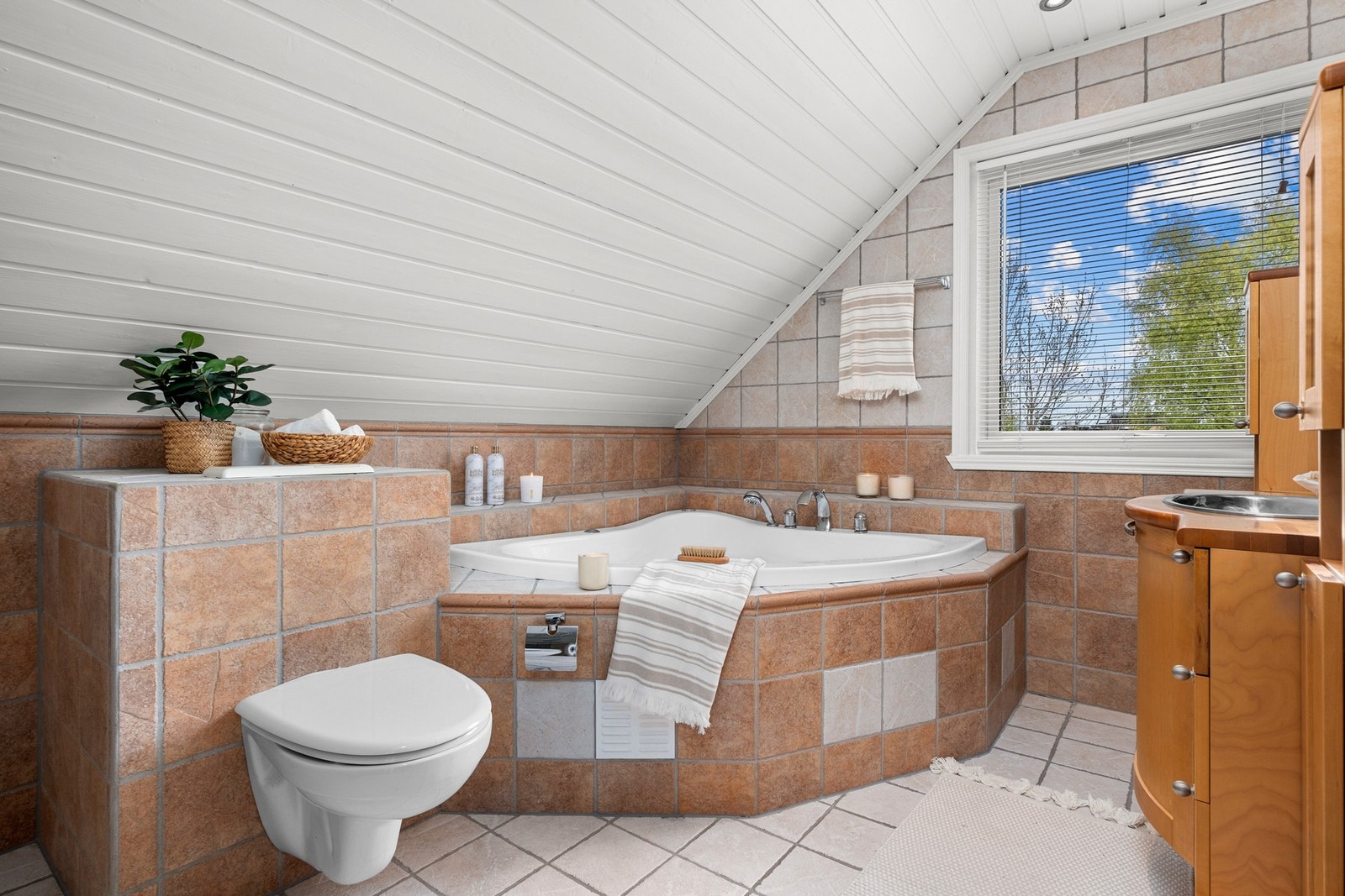 Klassisk flislagt bad fra byggeår med behagelig gulvvarme, og et romslig boblebad - en innbydende oase for avslapning. Galleribilde