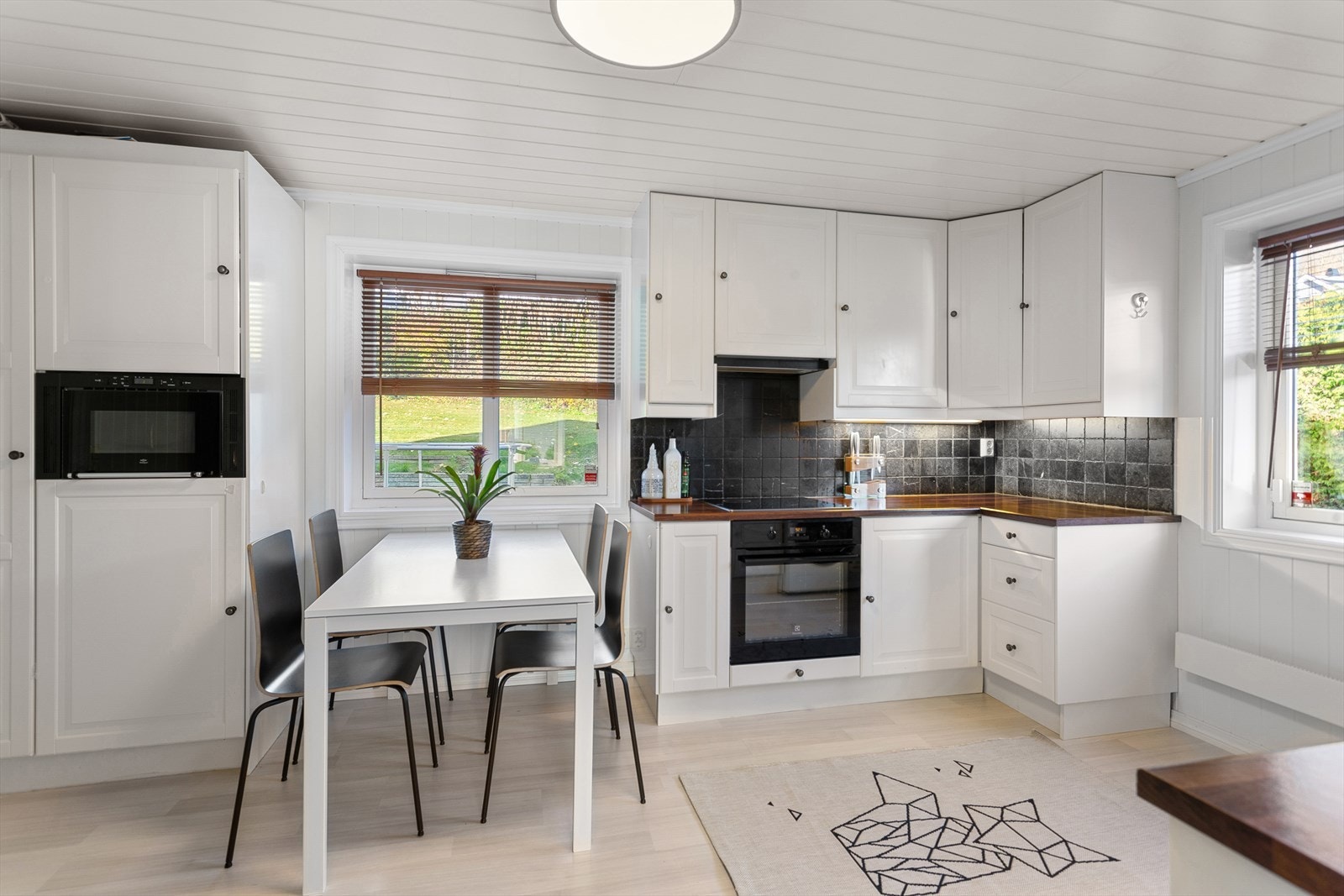 Vinduene slipper inn mye naturlig lys. Benkeplate er av laminat og mellom benk og skap er det fliser. Gode takhøyde skap med god plass til oppbevaring. Galleribilde