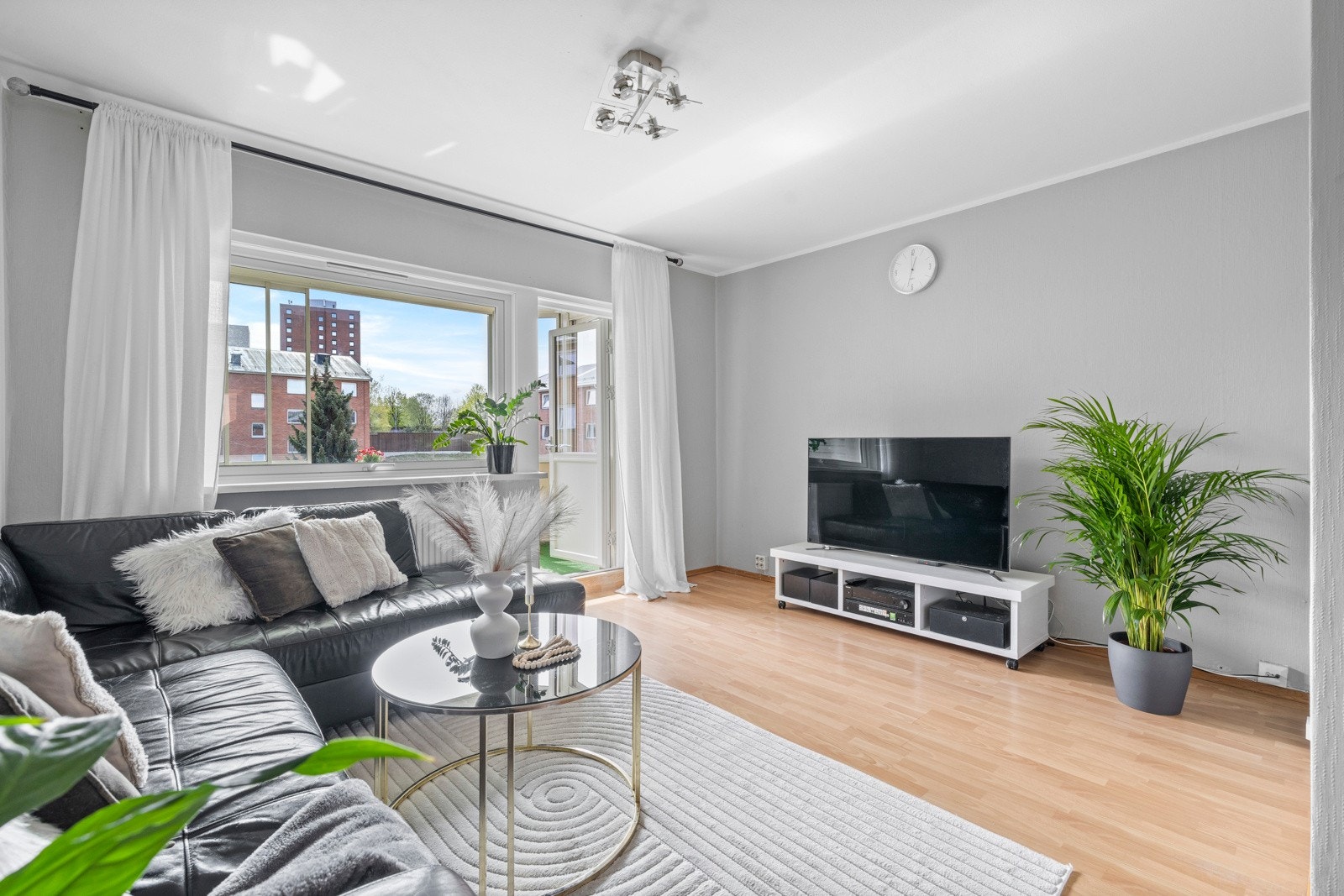 Gulvet er av parkett og de store vinduene gjør rommet lyst og luftig Galleribilde