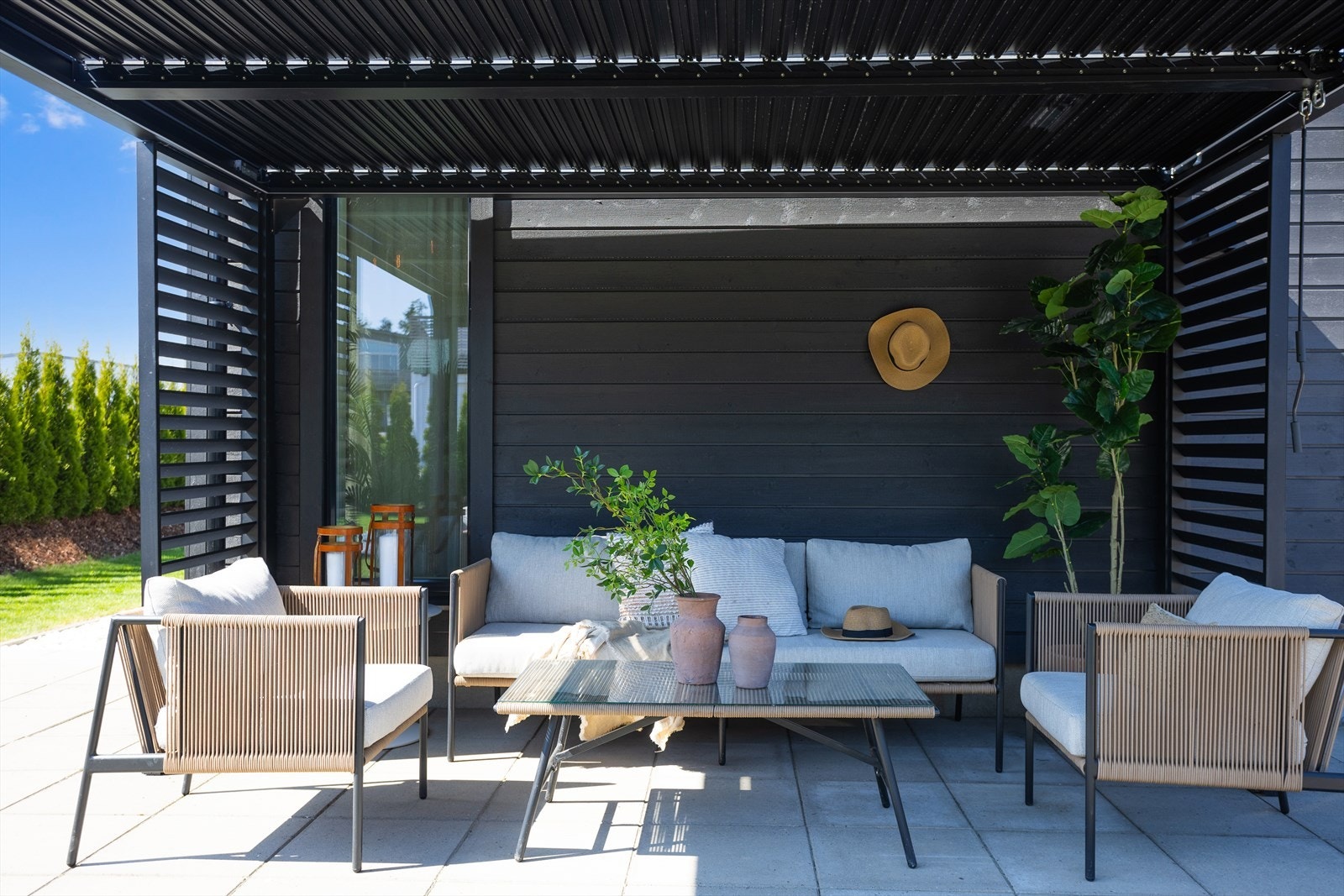 Stilig pergola ved inngangspartiet hvor selger forteller om fine kaffestunder i morgensolen mens barna hopper på trampolinen Galleribilde