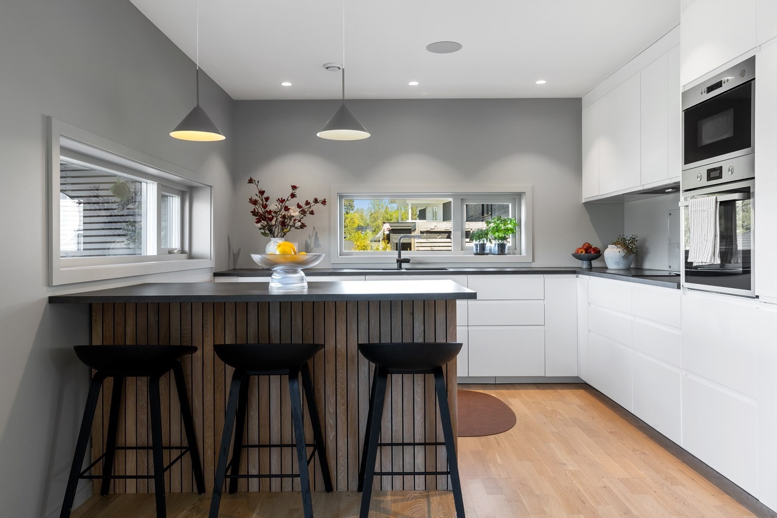 Lekkert kjøkken med glatte fronter og innfreset håndtak - Det er også montert høyttalere i taket her og i spisestue Galleribilde