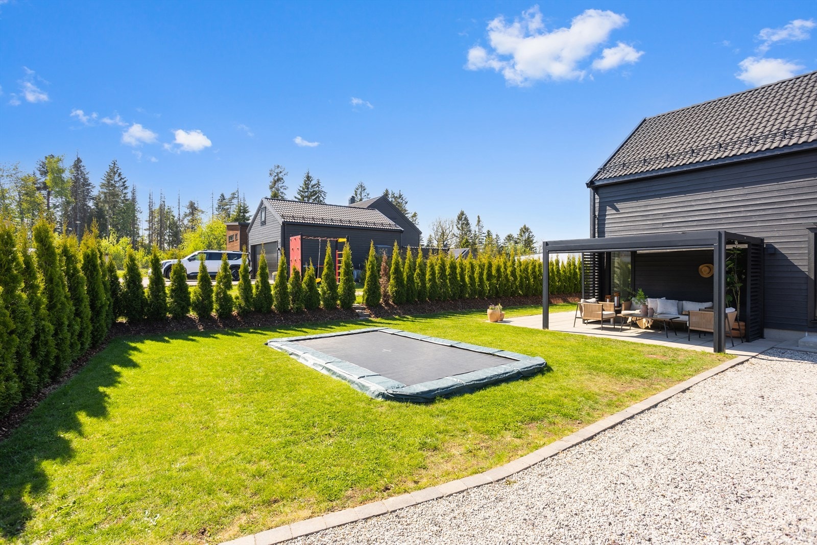 Det er en nedfelt trampoline i hagen som er perfekt for hyggelige stunder med barna Galleribilde