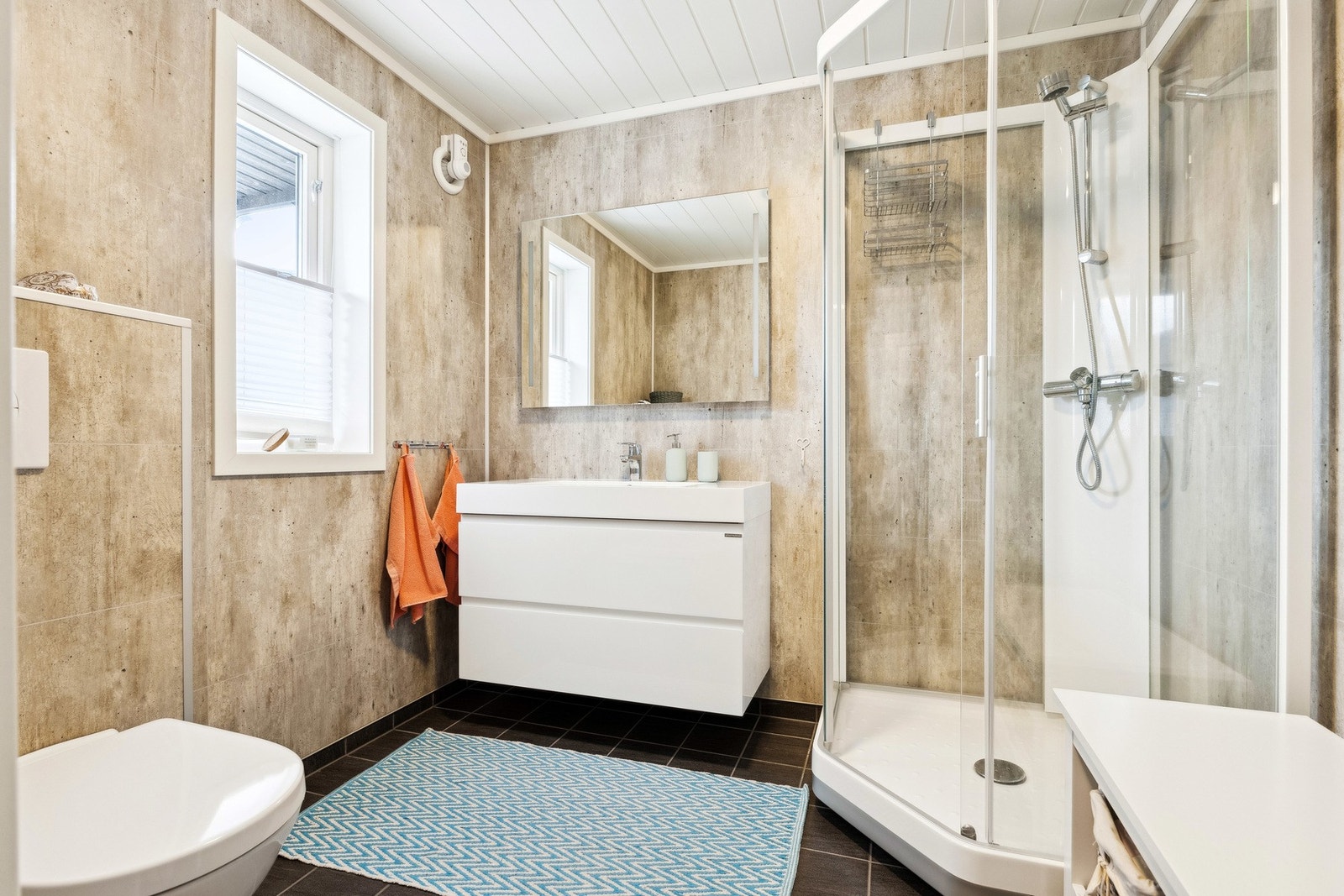 Badet har flislagt gulv og våtromsplater på vegger. Galleribilde