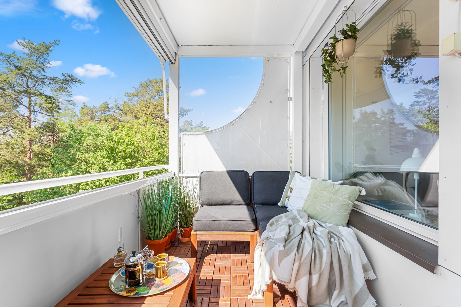 Balkongen er innglasset, og innglassingen kan enkelt skyves helt til side når man ønsker. Perfekt for å slippe våren og sommeren inn på varmere dager, samtidig som man kan skape en lunere uteplass ved kjølige kvelder. Galleribilde