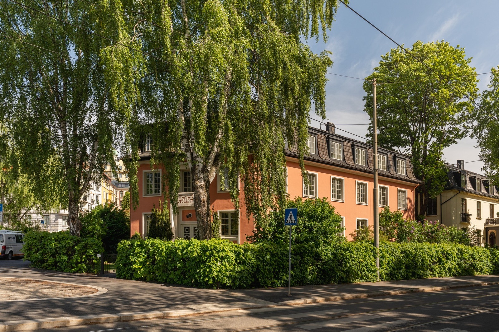 Leiligheten ligger med enkel adkomst i høy første etasje, skjermet av frodige prydbusker og hekk. Galleribilde