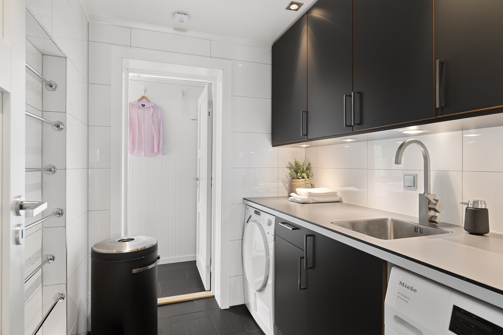 Praktisk vaskerom innredet med nisje for vaskemaskin og tørketrommel Galleribilde