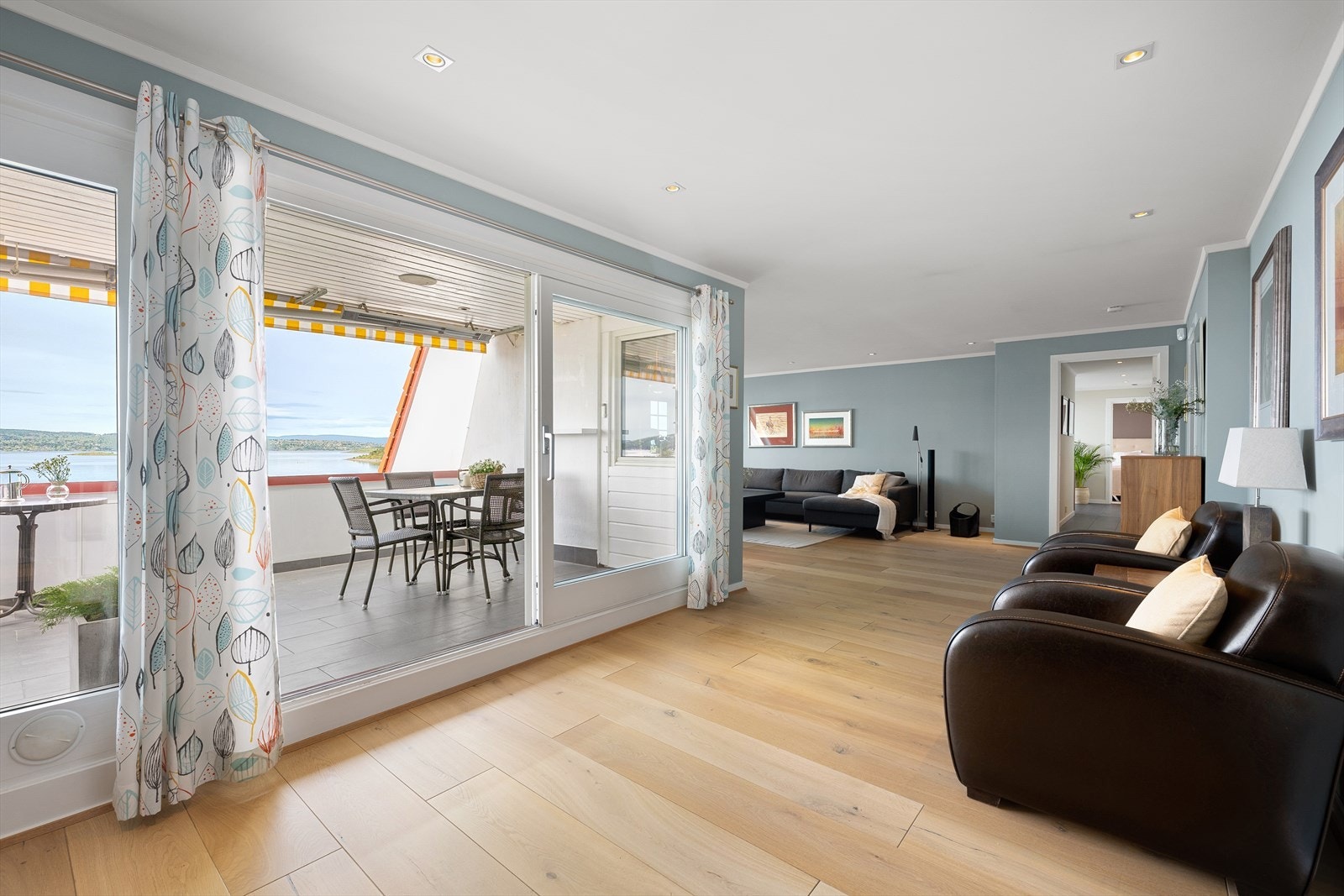 De store vindusflatene og utsikten gir rommet en luftig og lys atmosfære Galleribilde