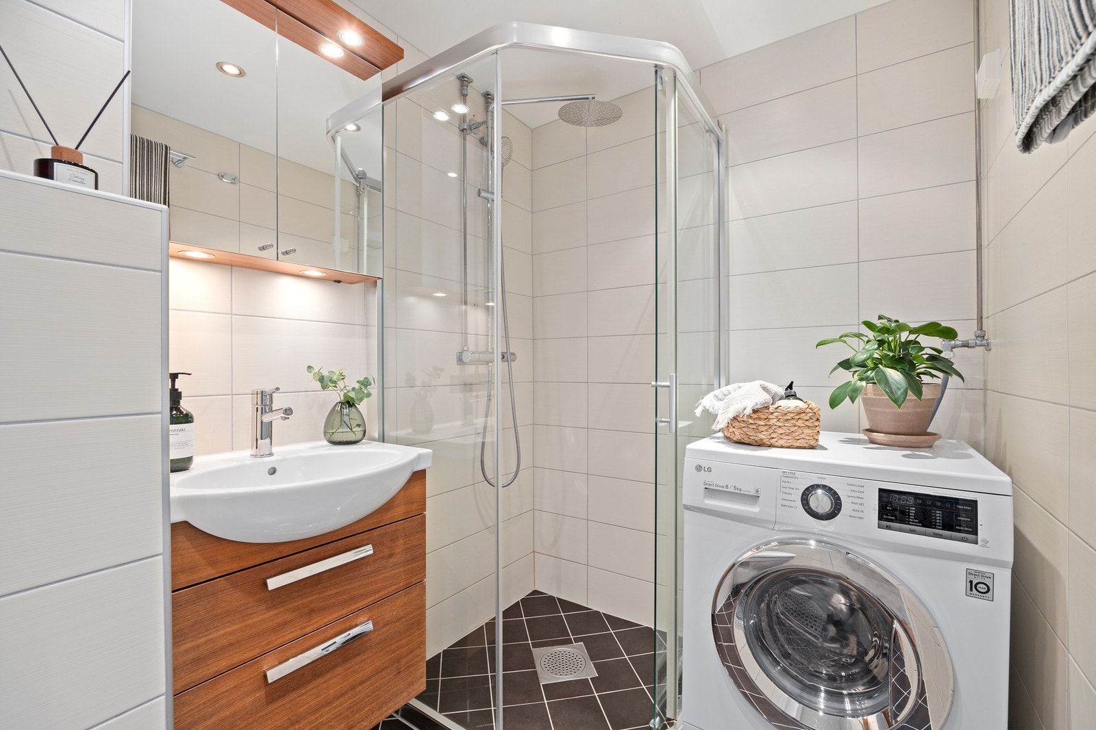 Badet har et dusjhjørne med skyvedør, utstyrt med veggmontert dusjarmatur som betjener både hånddusj og regndusj. Galleribilde