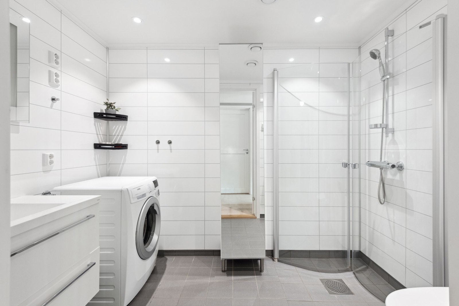 Badet har flis på gulv med varme og opplegg for vaskemaskin. Galleribilde