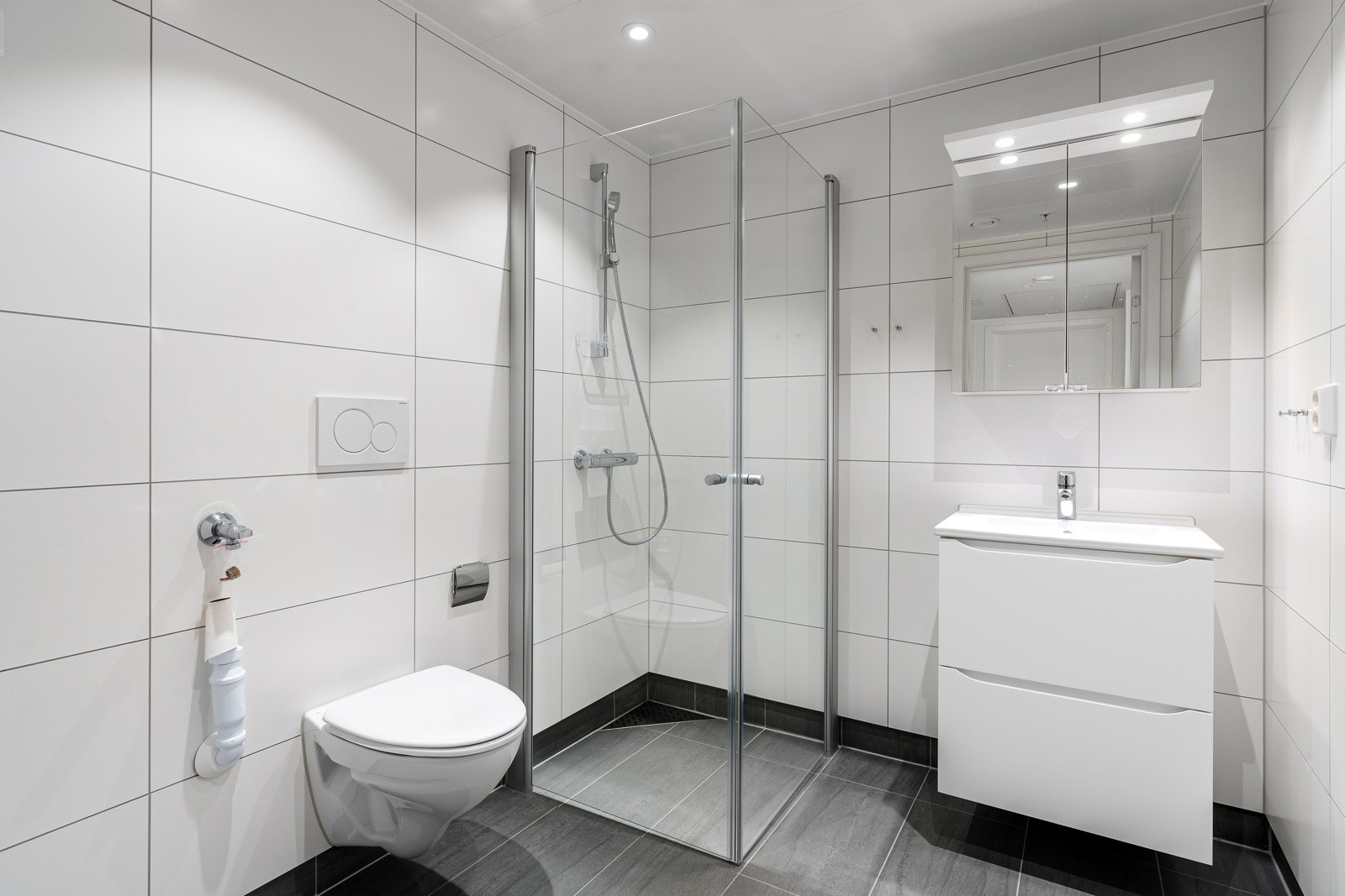 Pent flislagt baderom med downlights i himling og varme i gulv.
