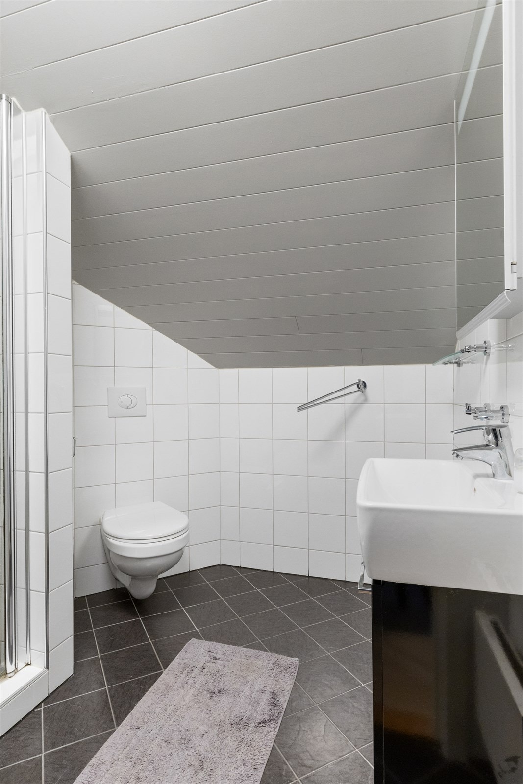 Badet har dusjnisje med foldedører av glass Galleribilde