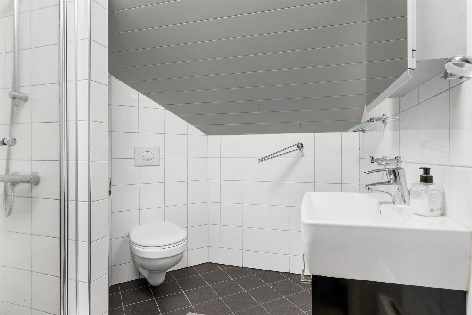 Flislagt bad med fliser på gulv, fliser på vegger og malt panel Galleribilde