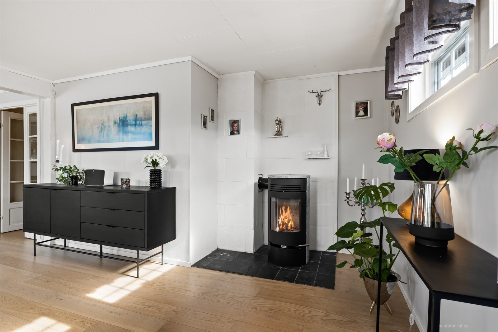 Frittstående peisovn med fliser på gulv og malt murvegg Galleribilde