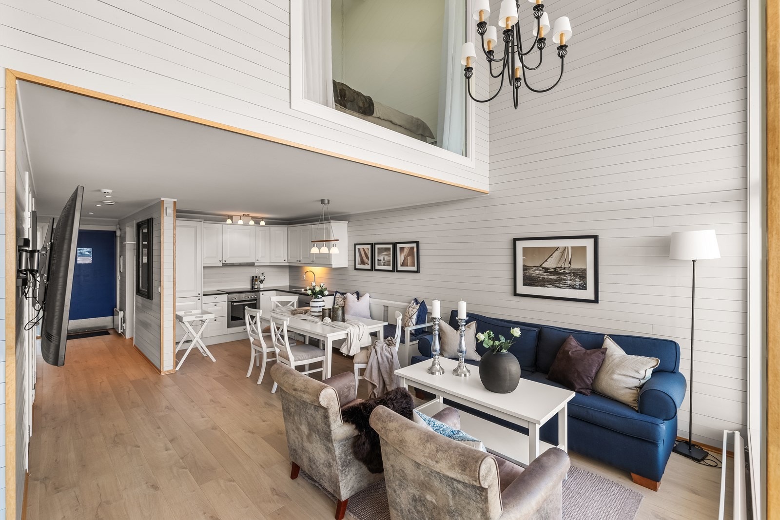 Den åpne stue- og kjøkkenløsningen har et stilrent kjøkken med integrerte hvitevarer. Galleribilde