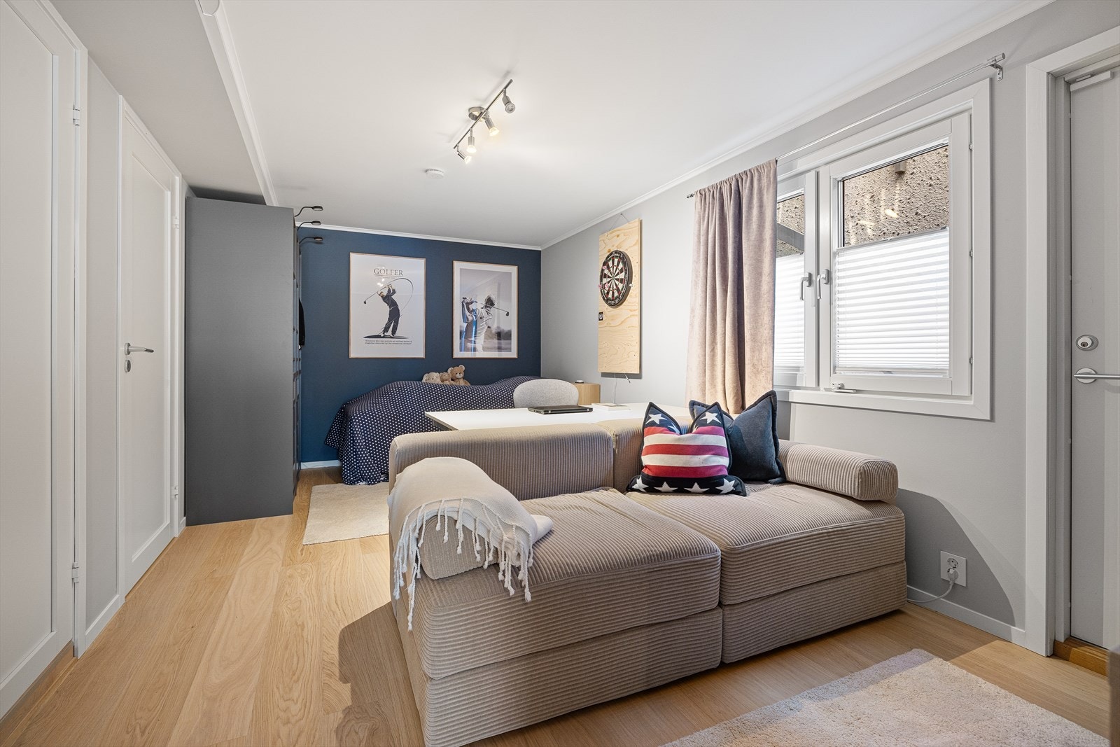 Stort soverom/stue innredet med garderobeskap, samt plass til seng, sofa, skrivebord m.m. Galleribilde