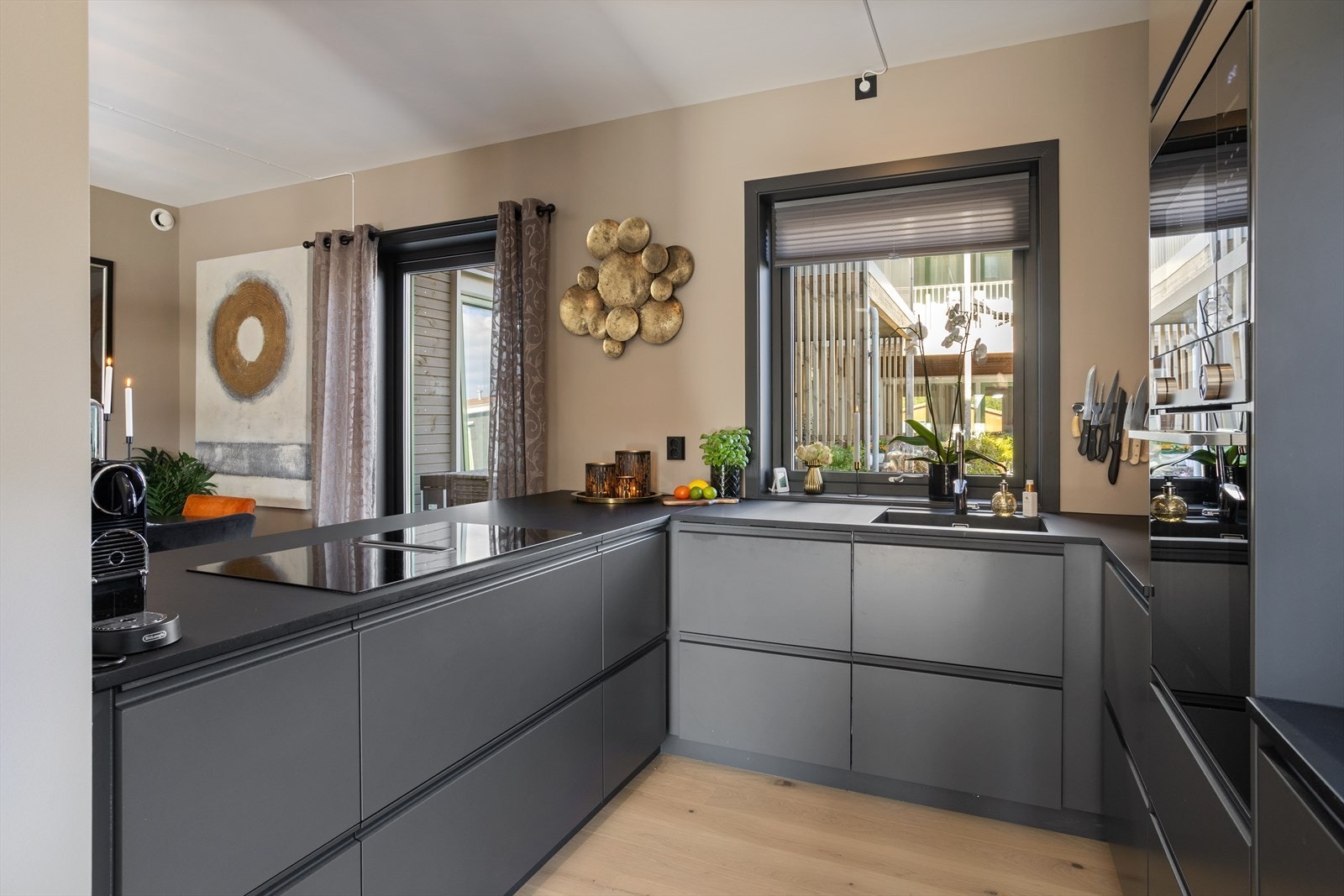 Den åpne planløsningen og den moderne samt påkostende kjøkkeninnredningen gjør rommet til ett av hjemmets naturlige midtpunkt. Galleribilde