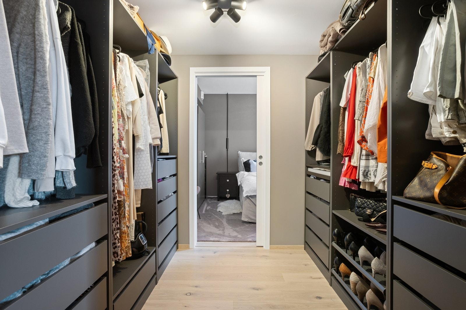 Walk in garderoben har innredning på begge langssider med blant annet uttrekksskuffer uttrekkbare skohyller, faste hyller og hengeanordninger. Galleribilde