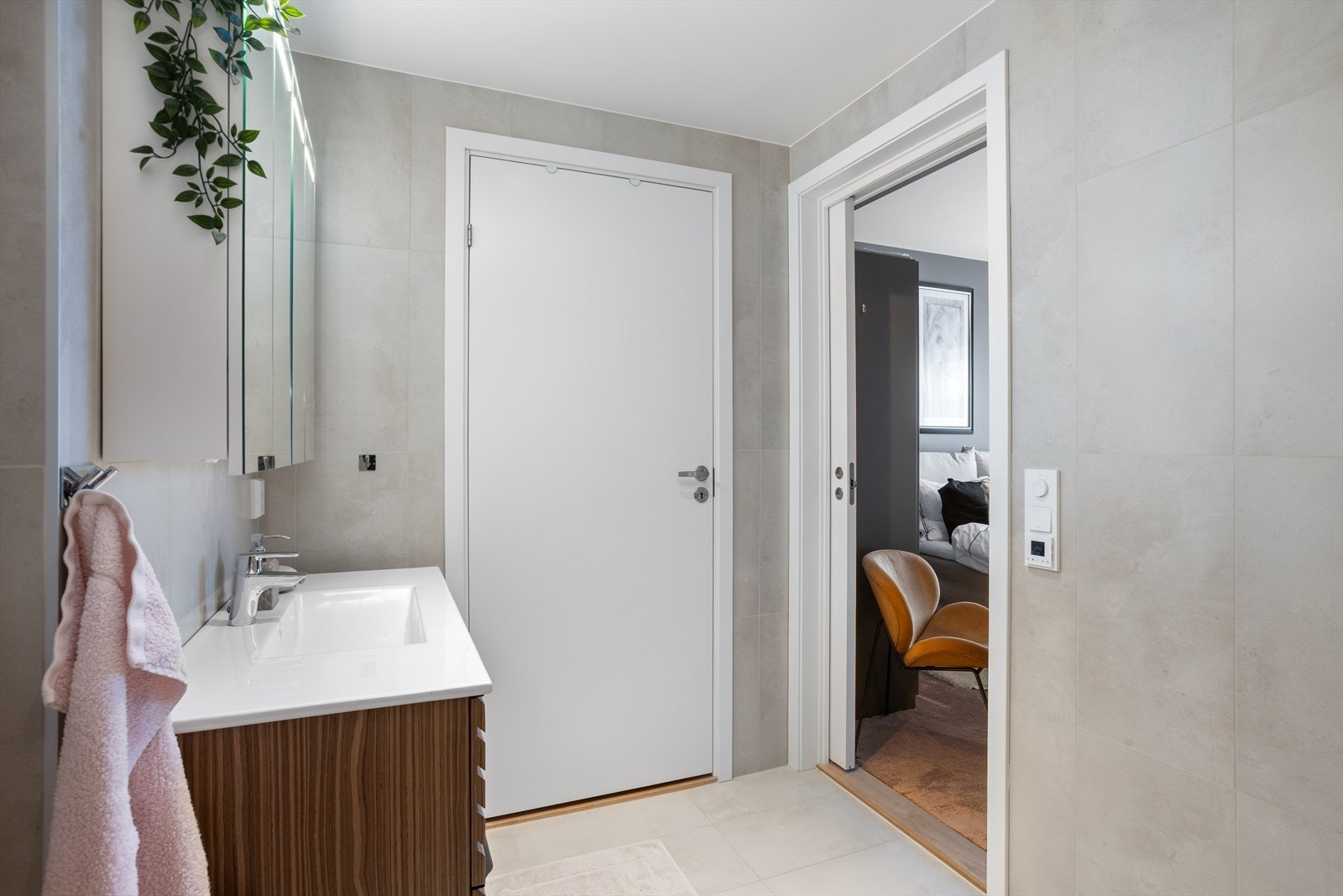 På hovedbadet, som blir leilighetens helt private sone, er det flislagte vegger og flislagt gulv - begge med "storformatfliser" i matt og elegant finish med behagelige farger i Spa-tema. Galleribilde