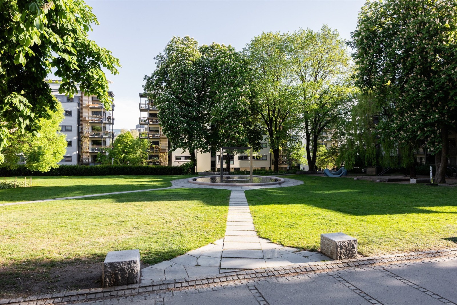 I parken er det fontene, lekeapparater, benker og flott beplantning. Galleribilde