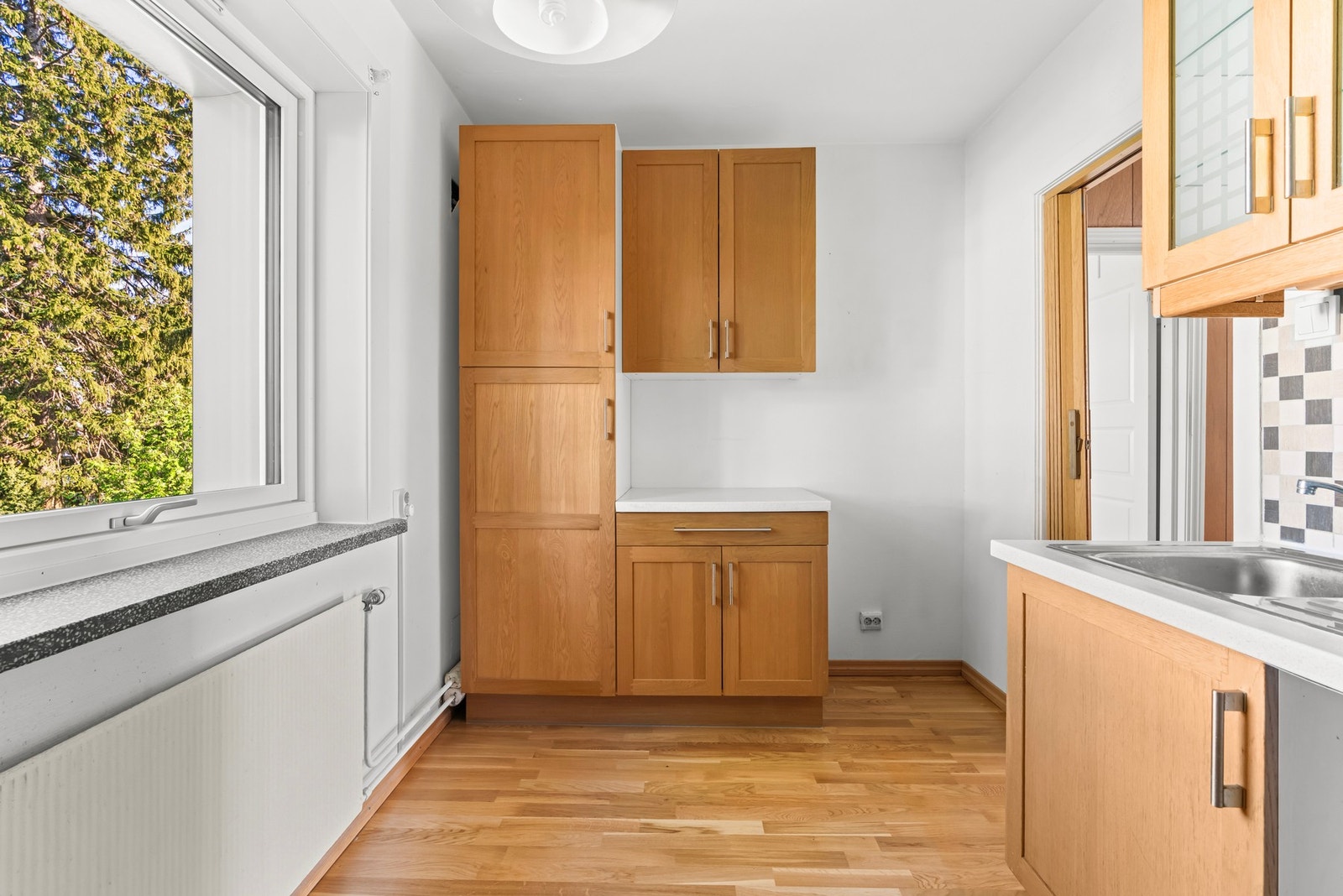 Kjøkkenets utforming byr på rikelig med skap- og benkeplasss fra to sider. Galleribilde