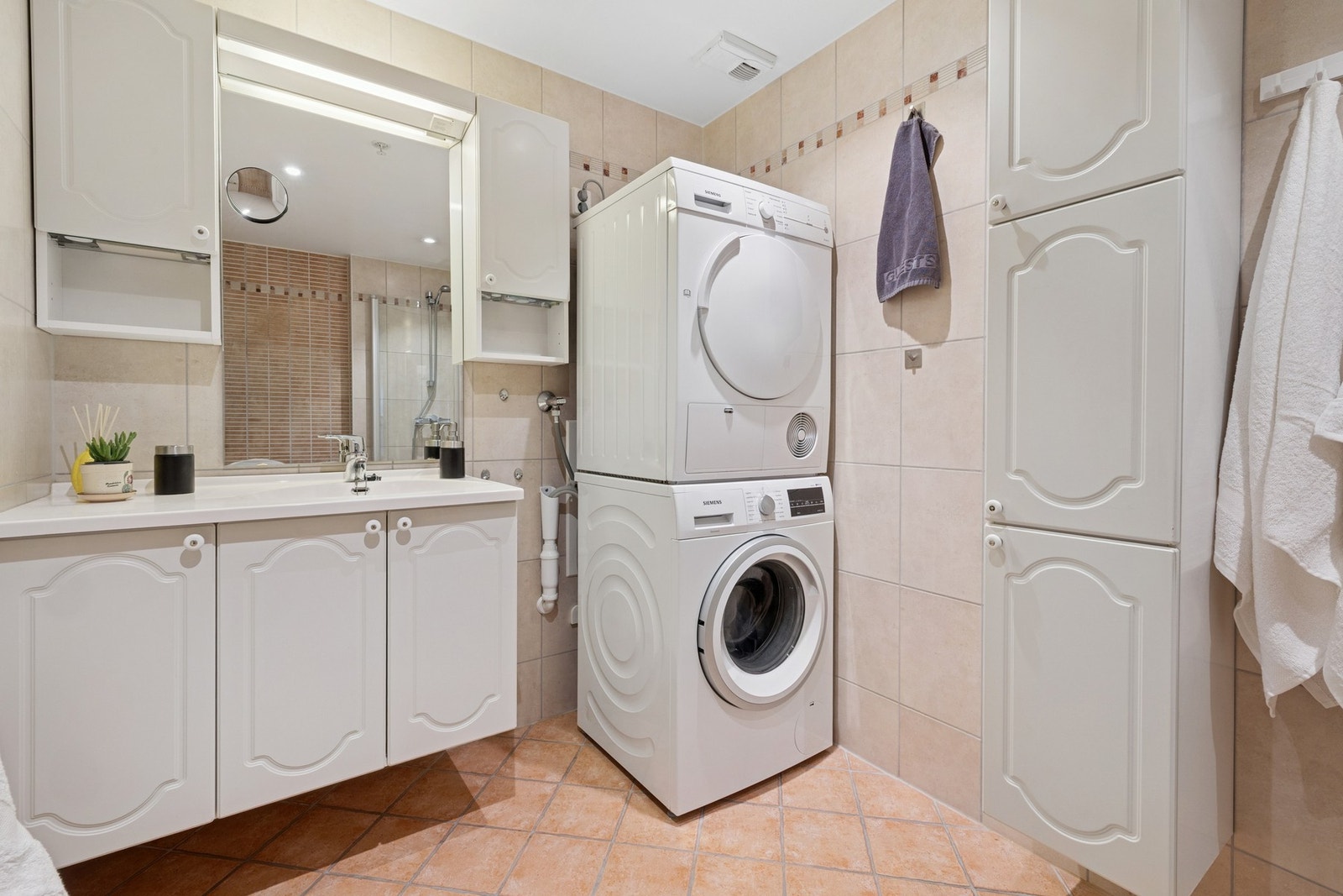 Badet har også vegghengt speil med overbelysning og opplegg for vaskemaskin og tørketrommel. Galleribilde