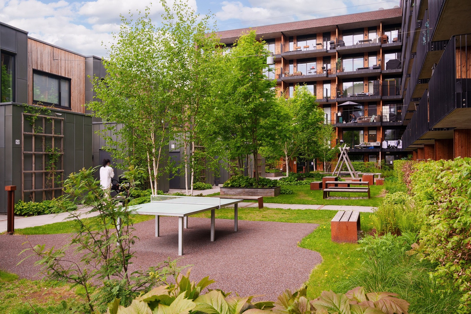 Pent opparbeidet uteområde med sittegrupper, bordtennis og huske - et hyggelig og sosialt fellesareal for både store og små. Galleribilde