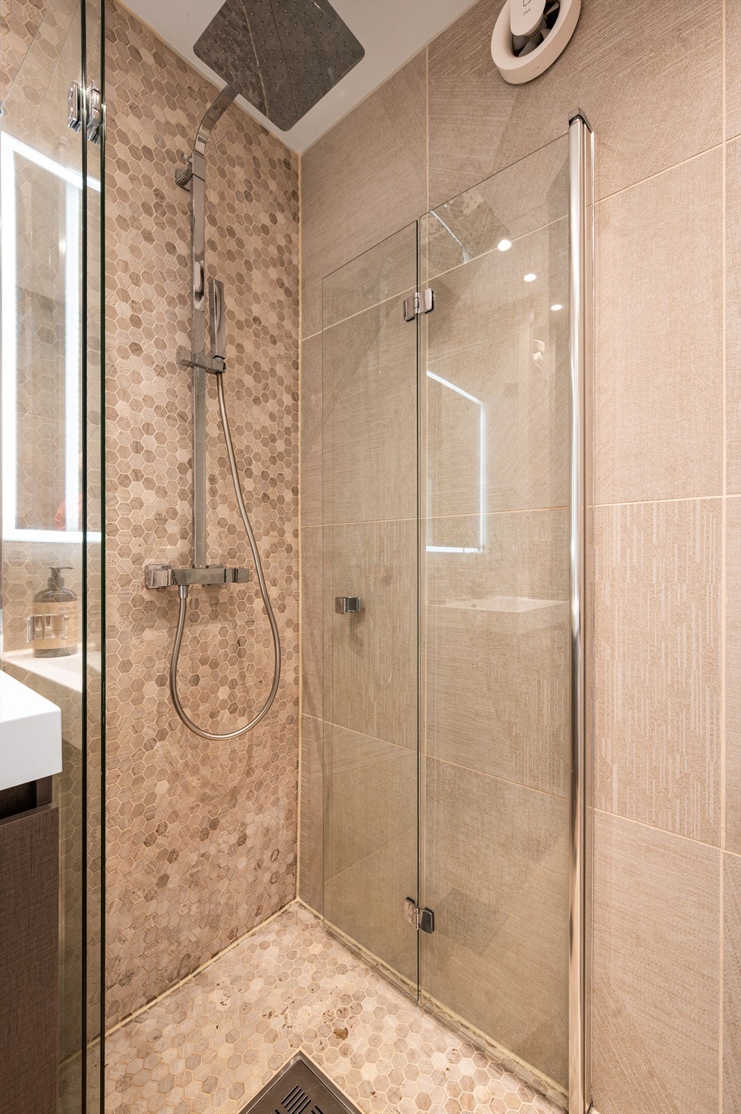 Videre har badet et dusjhjørne med svingbare glassdører. Galleribilde